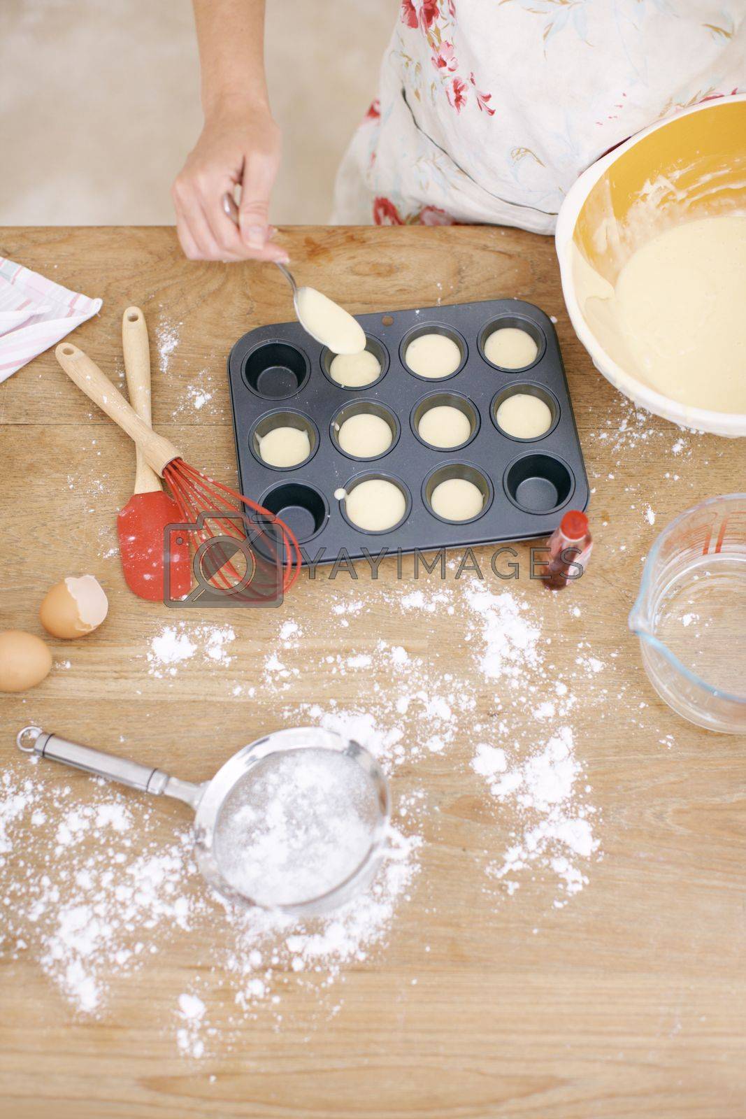 Royalty free image of Filling the baking tray. A woman placing cake mix into a baking tray. by YuriArcurs