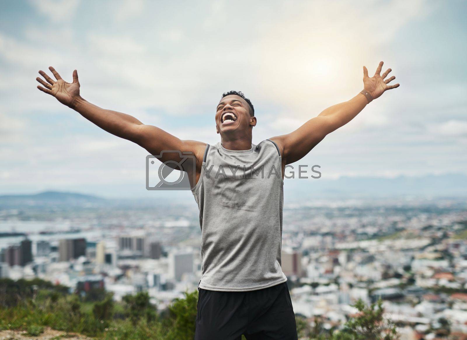 Royalty free image of Im the king of the world. a handsome young sportsman cheering in celebration outside. by YuriArcurs