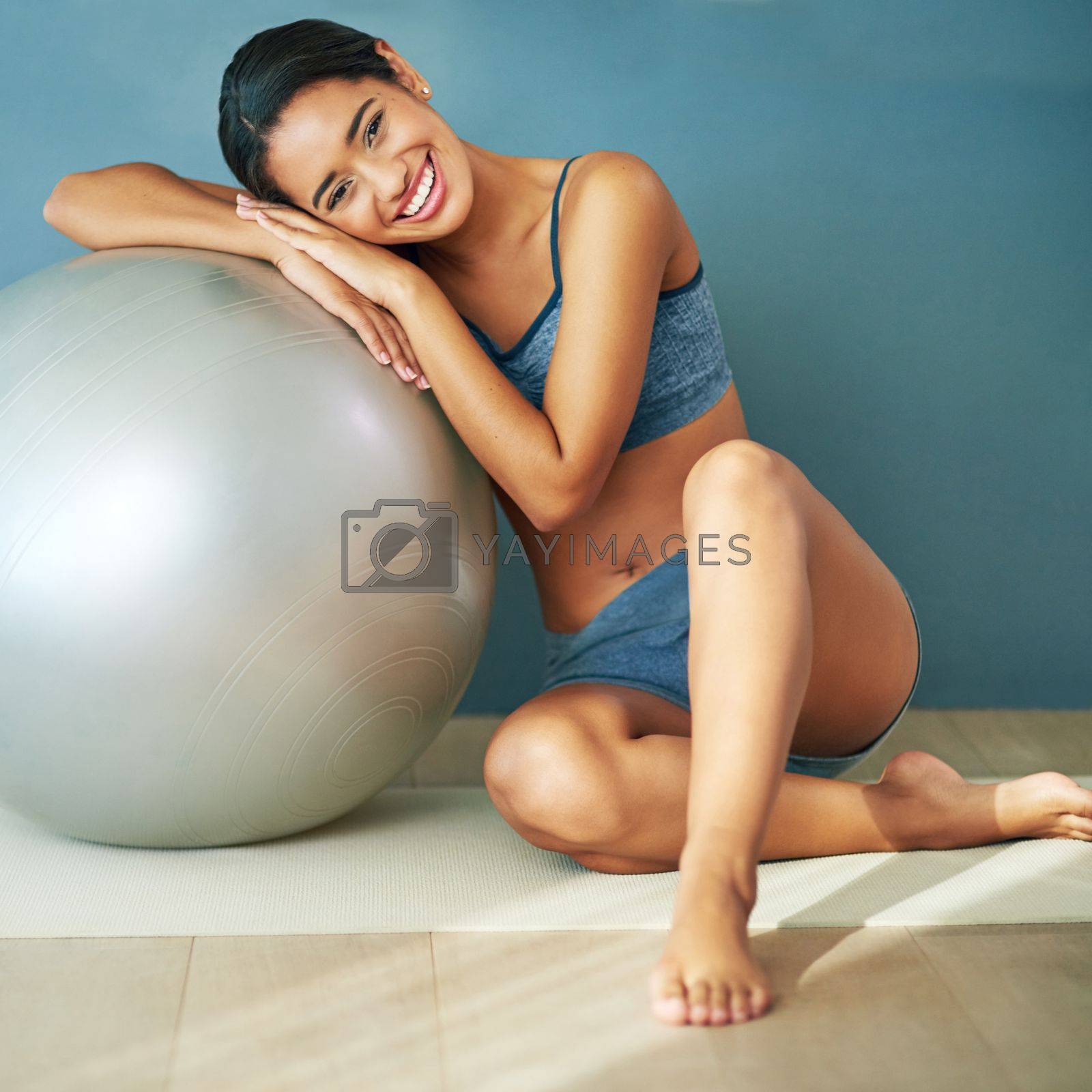 Royalty free image of Live a healthy life. a sporty young woman leaning against a pilates ball. by YuriArcurs