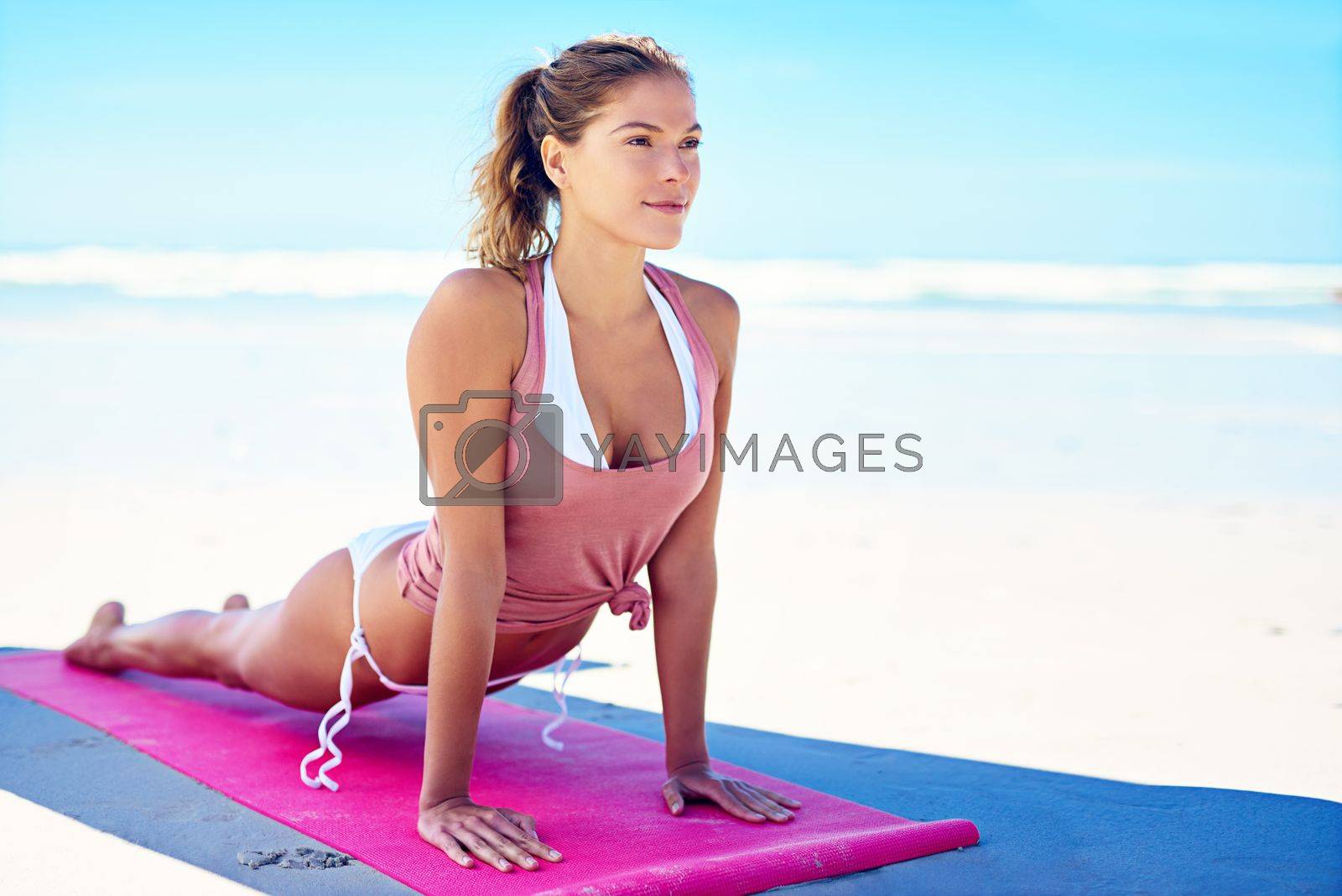 Royalty free image of Yoga is the journey of self. a young woman doing yoga at the beach. by YuriArcurs