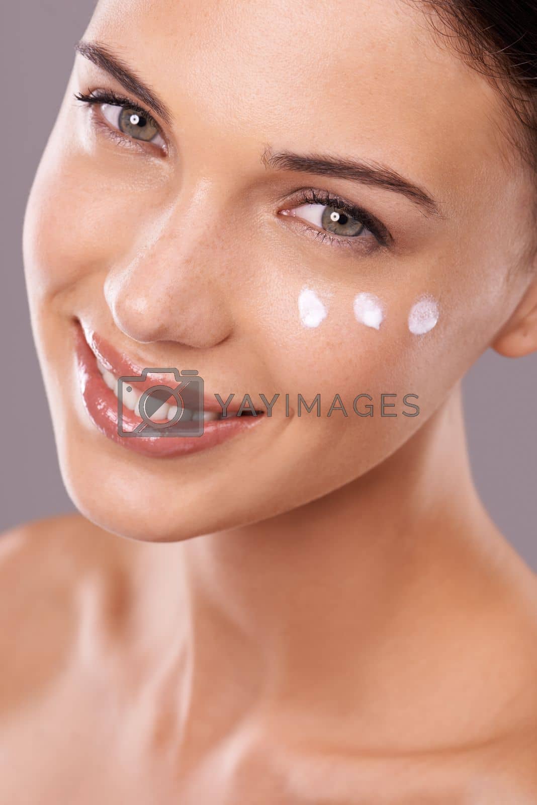 Royalty free image of Moisture is the basis for beauty. Studio shot of a beautiful young woman with dots of a skincare product on her face. by YuriArcurs