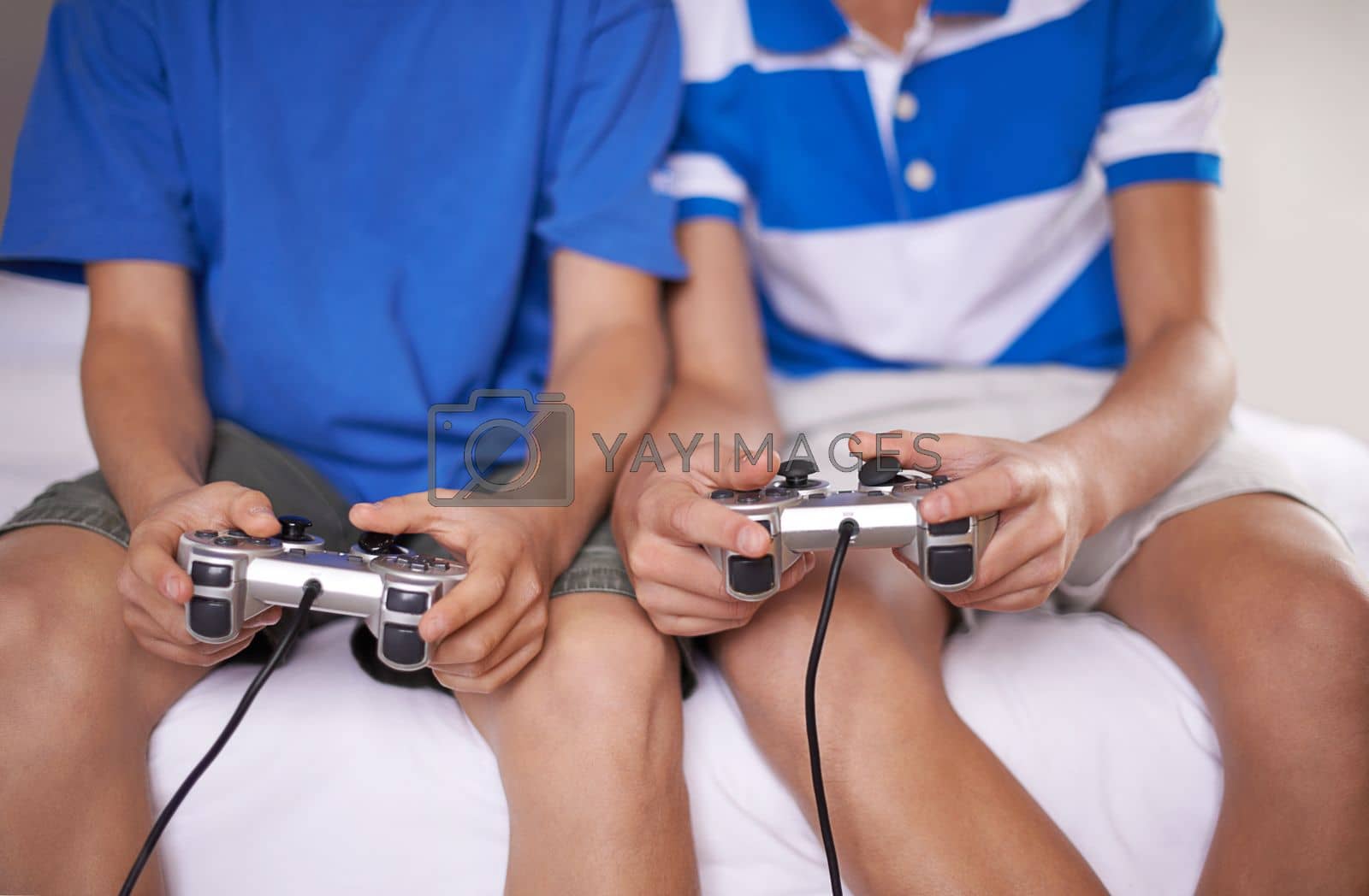 Royalty free image of Gaming with a friend. two young boys playing video games. by YuriArcurs