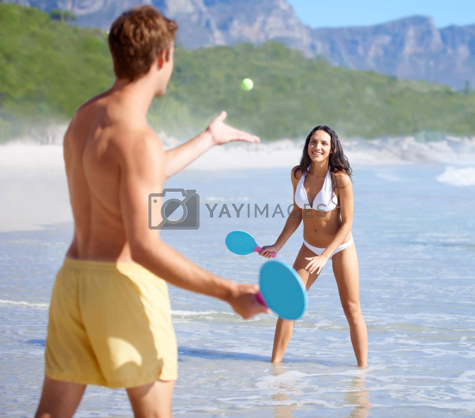 Royalty free image of They are always active. A happy young couple playing tennis on the beach together together. by YuriArcurs