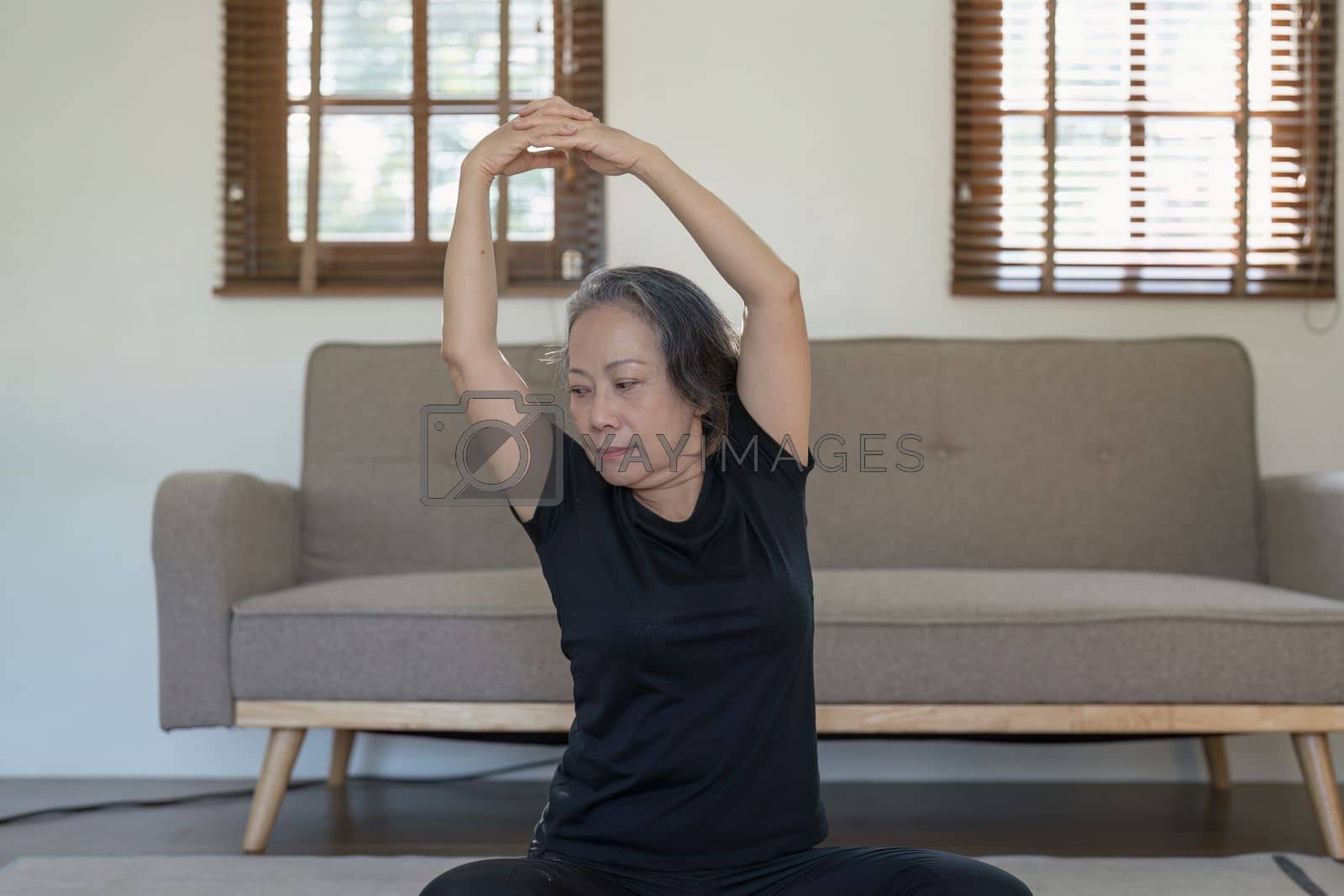 Royalty free image of Portrait of Mature Woman doing stretching yoga side bend. exercise and stretching concept by itchaznong