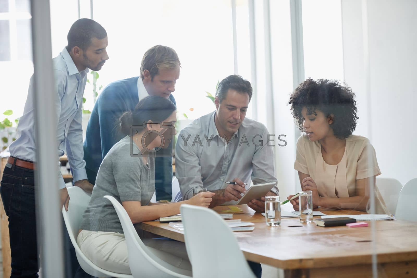 Royalty free image of We do extraordinary every day. a group of professionals using wireless technology during a meeting. by YuriArcurs