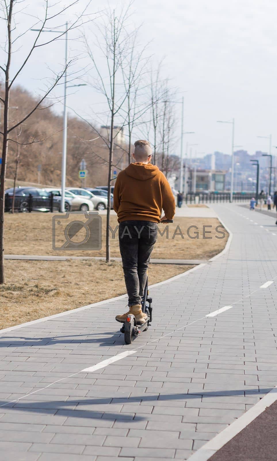 Royalty free image of Young man riding electric scooter in urban background. Modern transport and lifestyle concept. by Satura86
