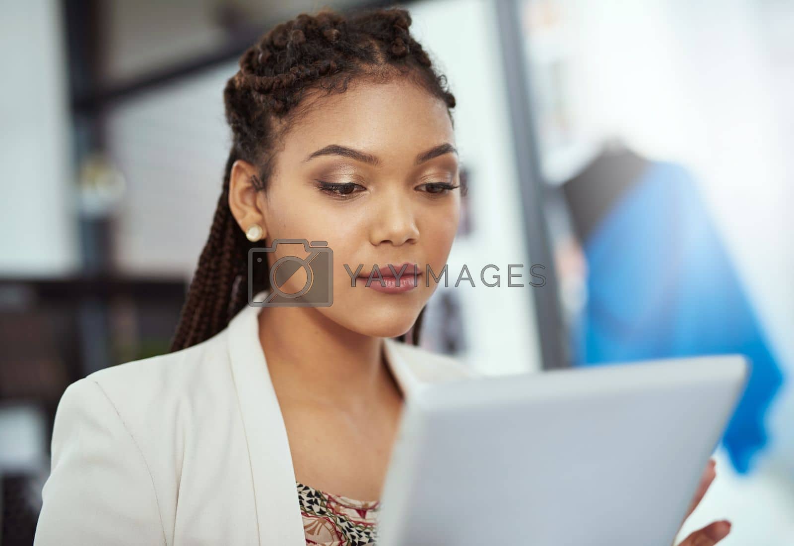 Royalty free image of Focused on fashion design. a young fashion designer working on her tablet. by YuriArcurs