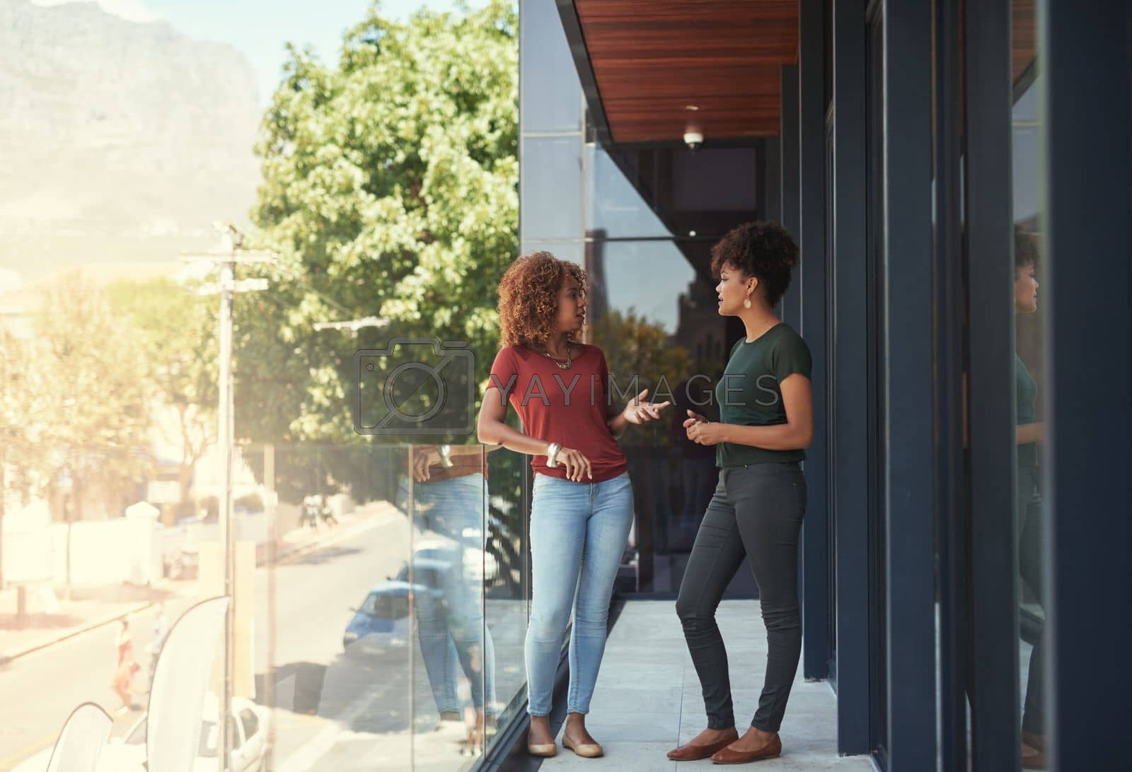 Royalty free image of Communication in the workplace is important. two businesswomen chatting outside on a balcony. by YuriArcurs