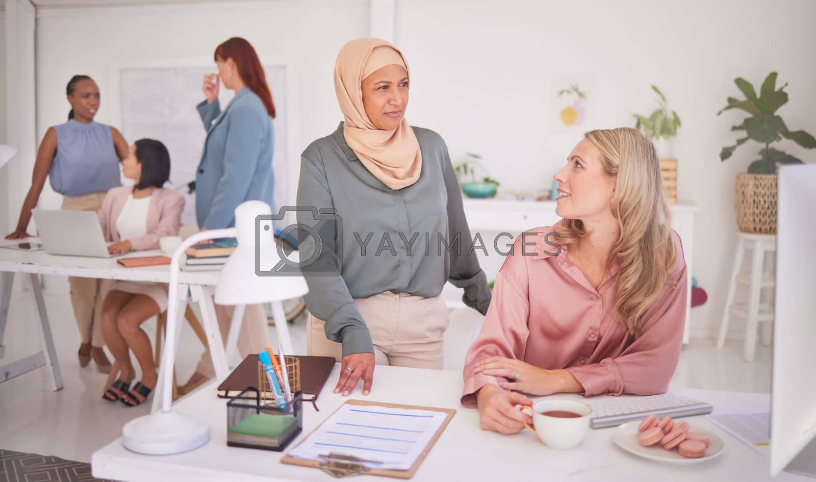 Business people, women and communication at desk in office, chatting or speaking. Thinking, meeting and ceo, leader or manager talking with employee or coworker on coffee break at company workplace