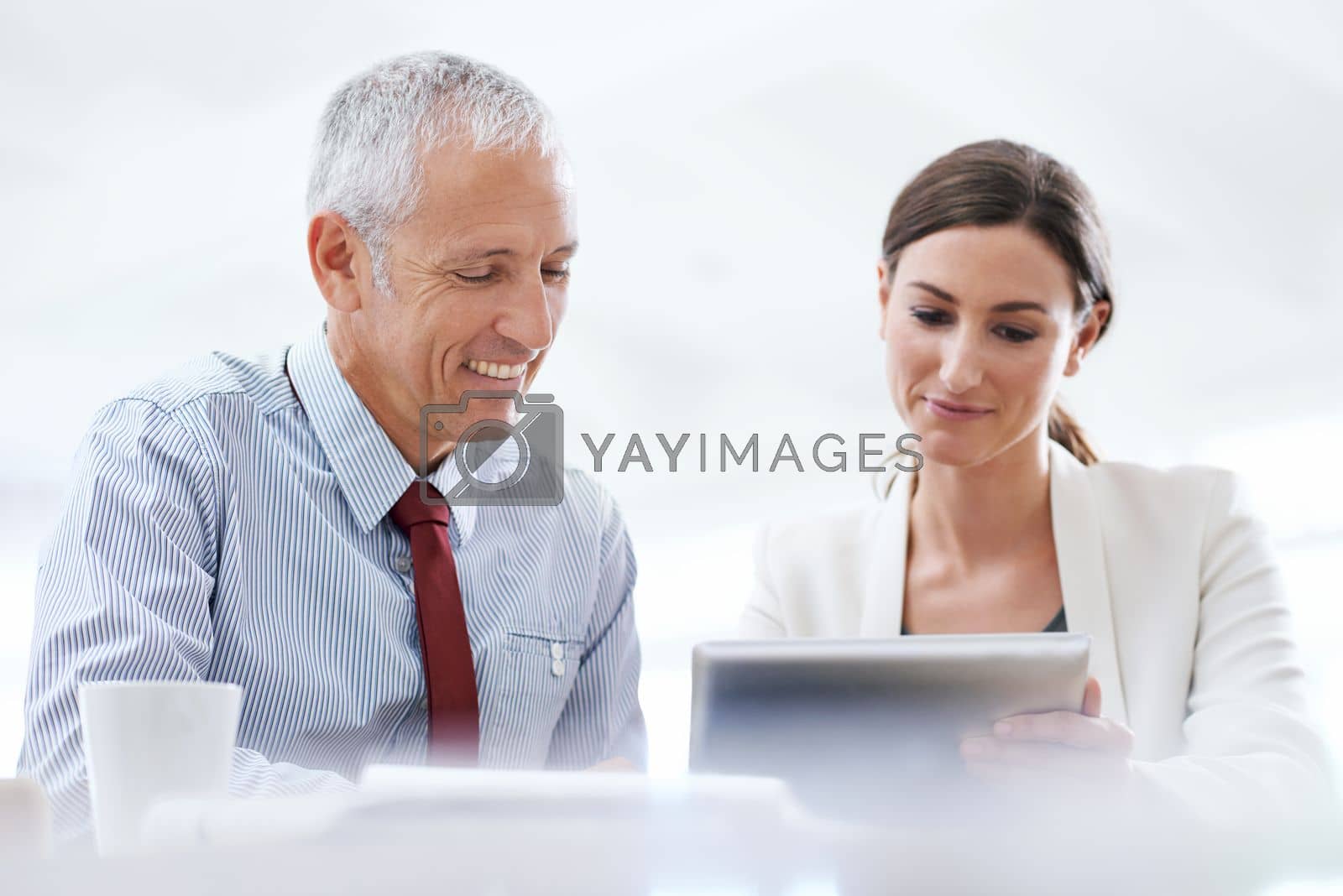 Royalty free image of Technology supporting business processes. two coworkers using a digital tablet at work. by YuriArcurs