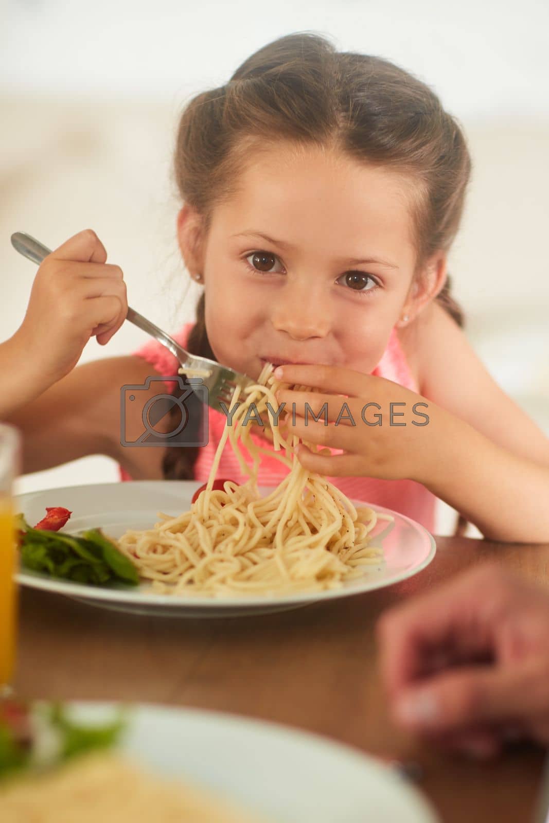 Royalty free image of I asked mom to make my favorite. an adorable little girl eating her food at home. by YuriArcurs