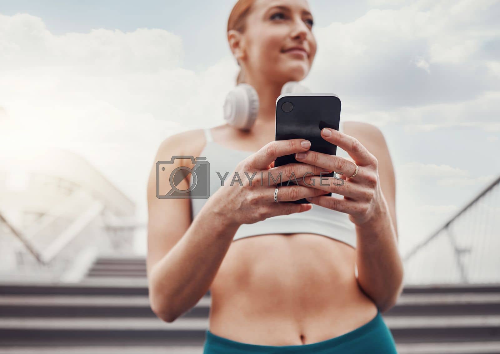 City, fitness and woman with smartphone, communication and smile typing after exercise low angle. Health, workout and personal trainer on phone, conversation and connect or network in sports training.