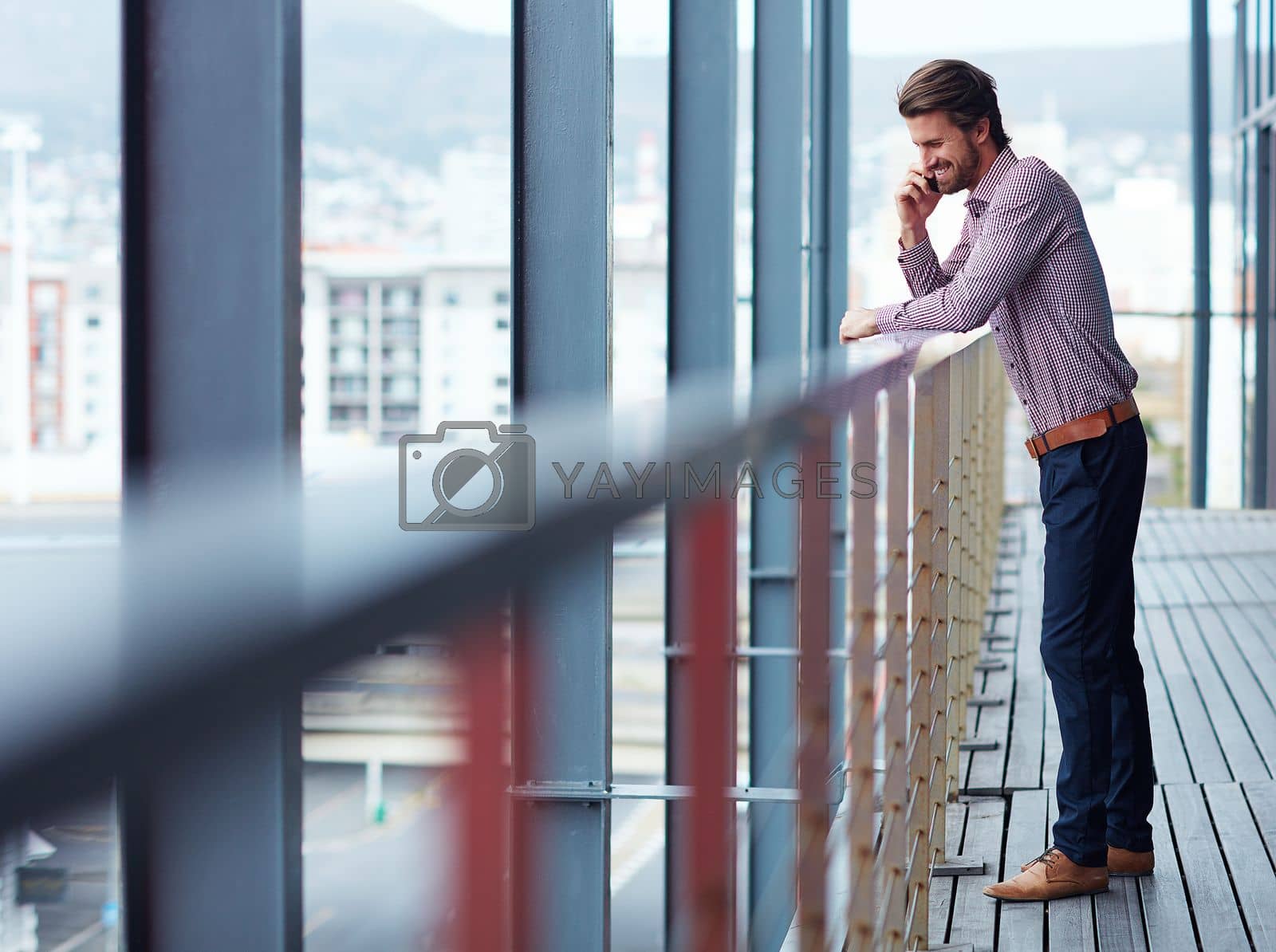 Royalty free image of Effective communication makes for effortless business. a young businessman talking on a phone outside of an office building. by YuriArcurs