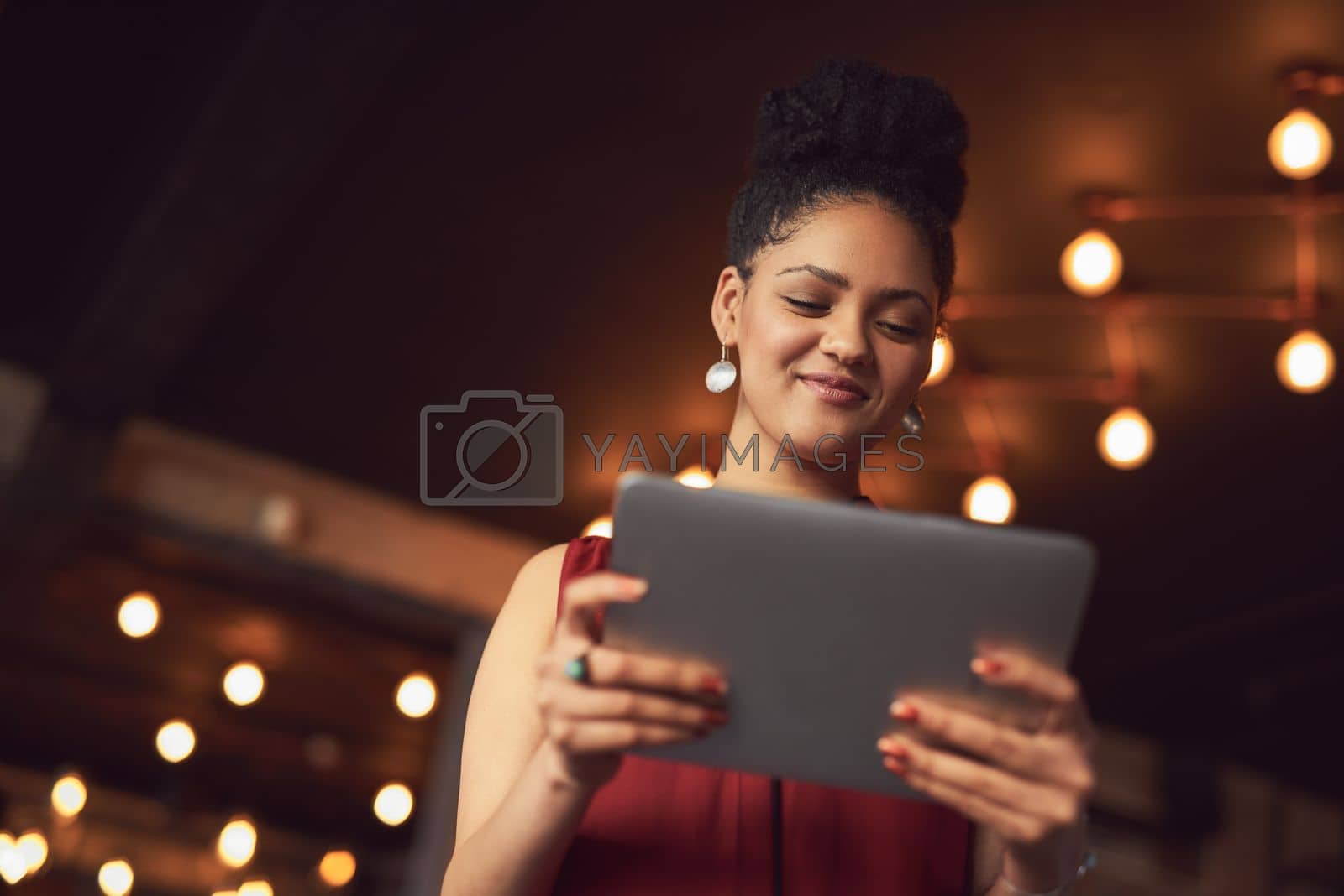 Royalty free image of Browsing at leisure. a young woman using a digital tablet in a cafe. by YuriArcurs