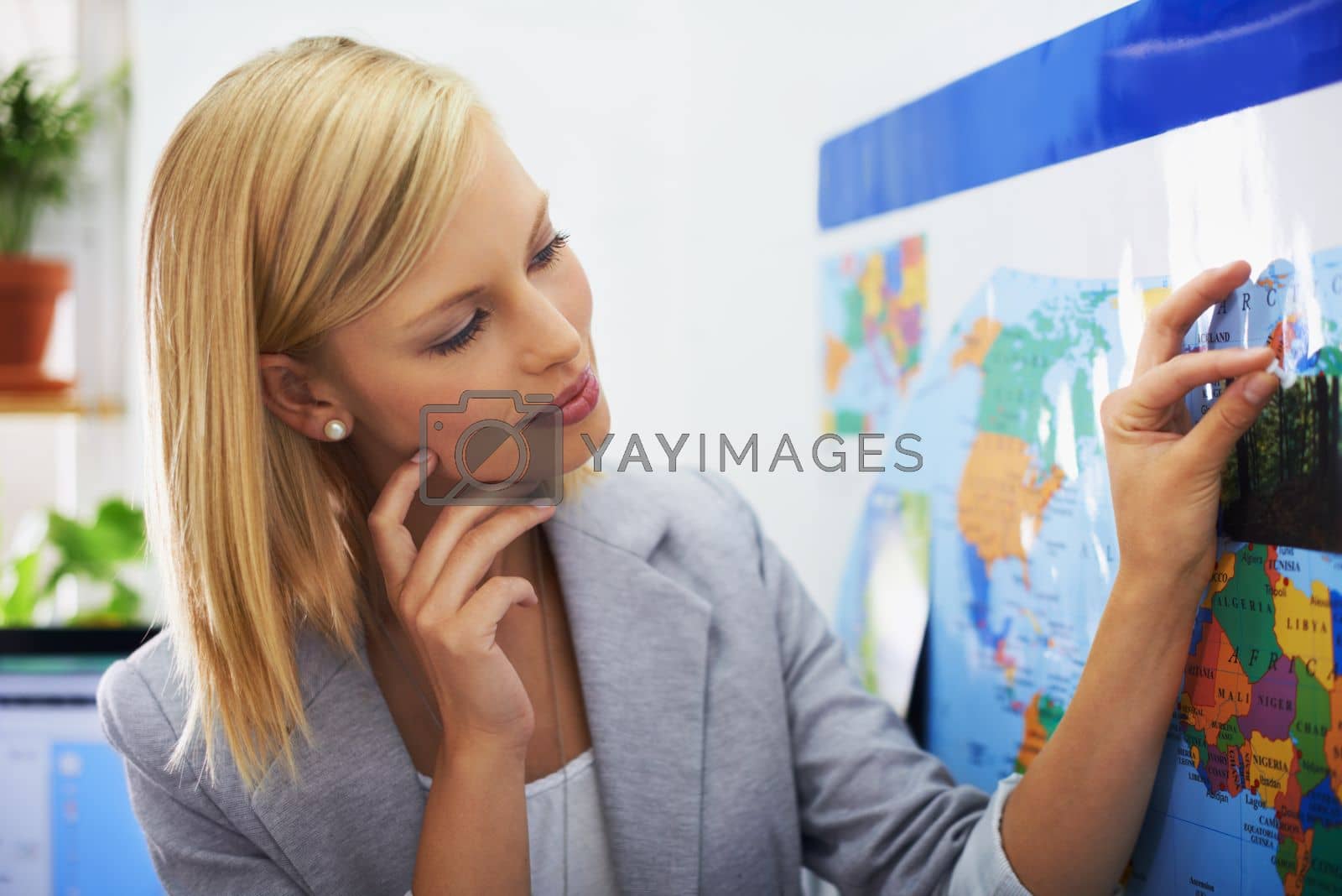 Royalty free image of Shes planning to travel the world. A beautiful young woman planning an overseas trip. by YuriArcurs