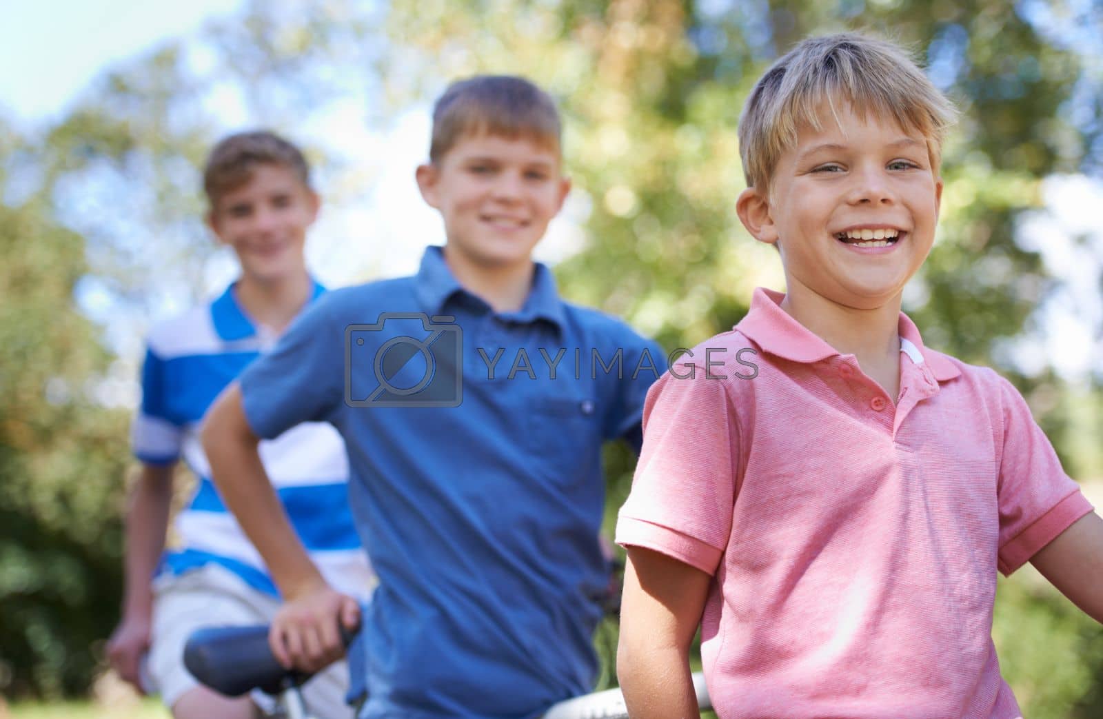 Royalty free image of Out for an awesome bike ride. Three brothers out for a bike ride in the forest together. by YuriArcurs