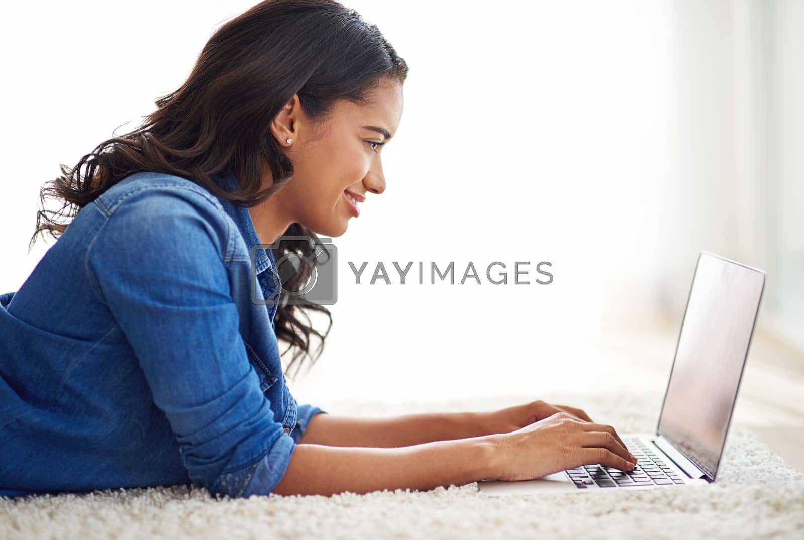 Royalty free image of Happy, relax or woman on laptop for networking, communication or social media review on living room floor. Search, email or girl working with smile writing blog, marketing or advertising content by YuriArcurs