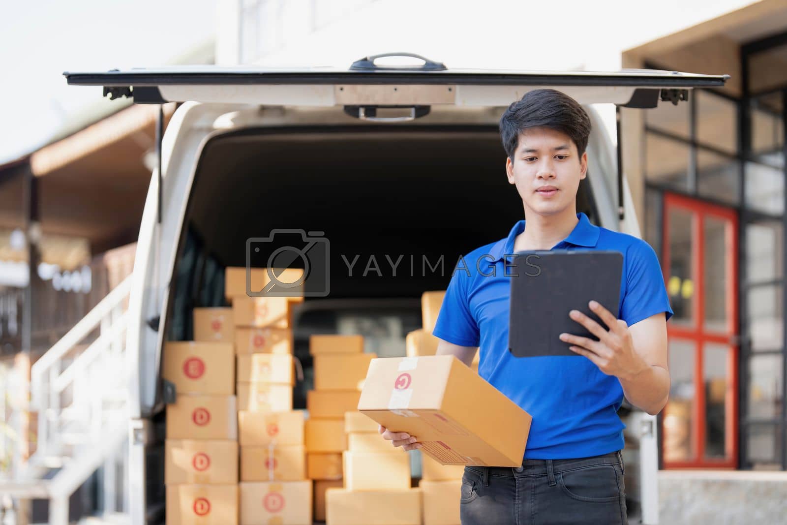 Royalty free image of Asian courier with parcel and delivery logistic concept. Delivery man with checking list on clipboard by wichayada