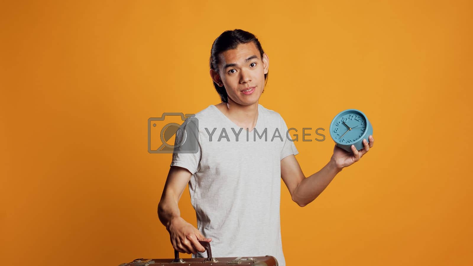 Royalty free image of Male person carrying suitcase and checking time on clock by DCStudio