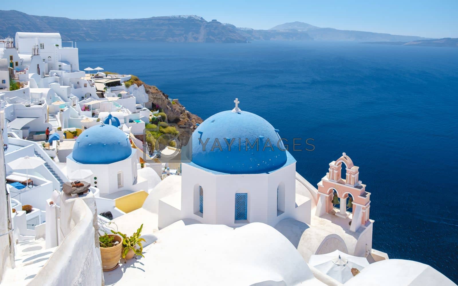 Royalty free image of White churches an blue domes by the ocean of Oia Santorini Greece, traditional Greek village by fokkebok