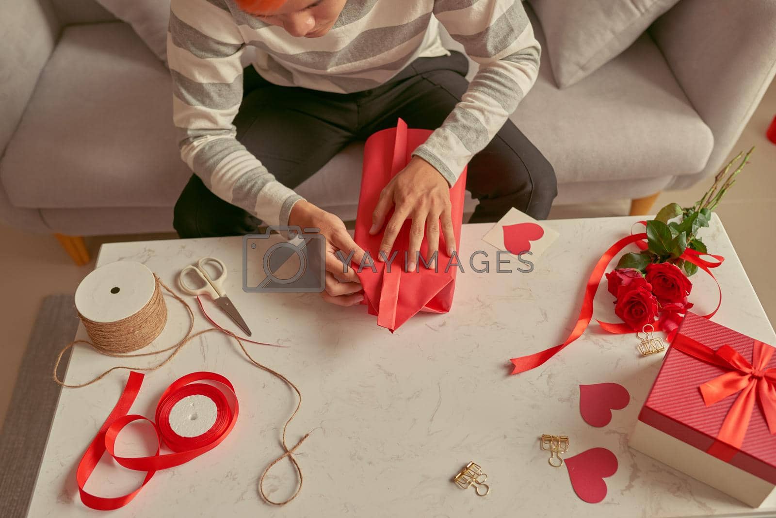 Royalty free image of Handsome romantic guy making present for his soul mate by makidotvn