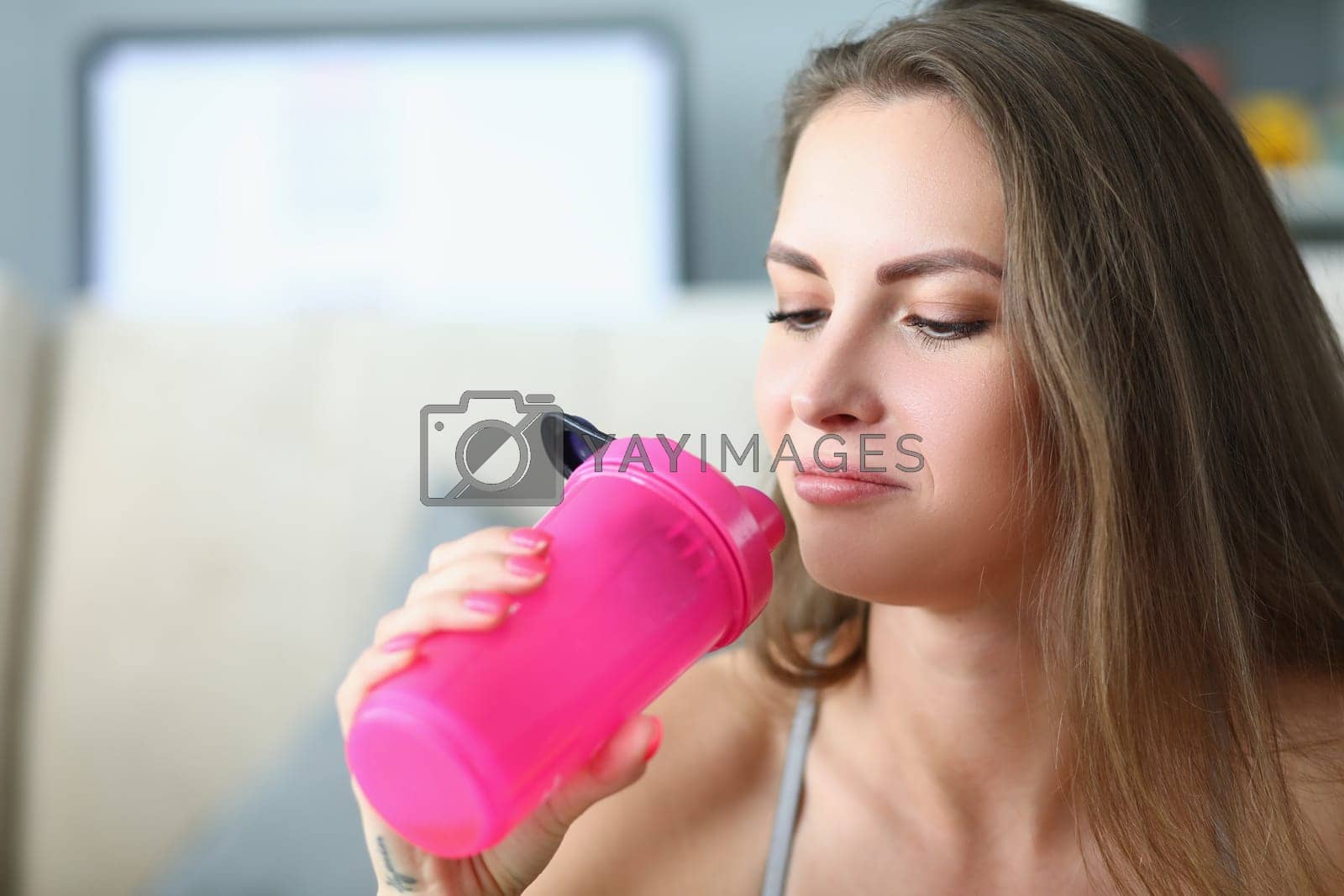 Royalty free image of Portrait of young calm pensive woman with bottle of water by kuprevich