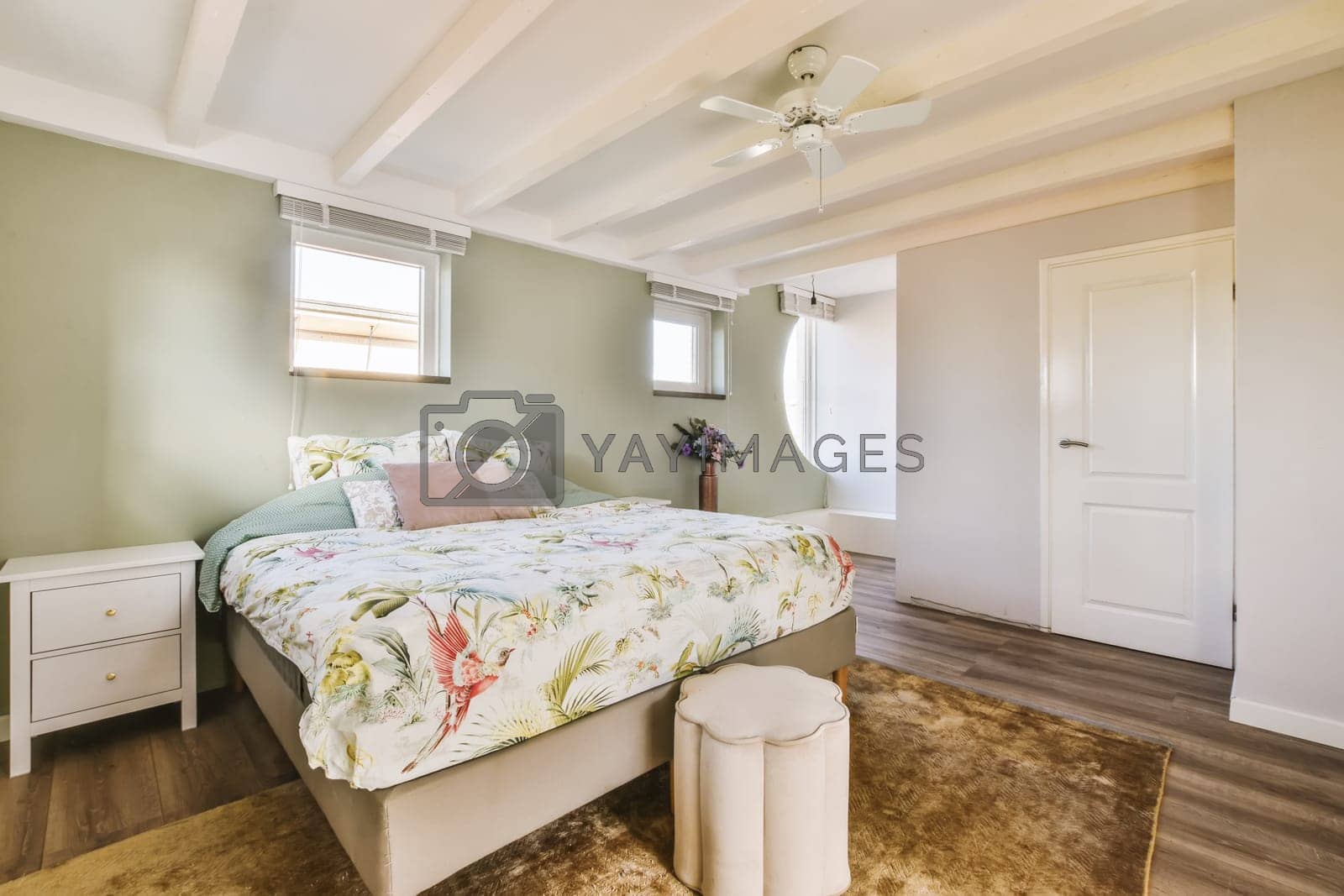 Royalty free image of a bedroom with a bed and a ceiling fan by casamedia