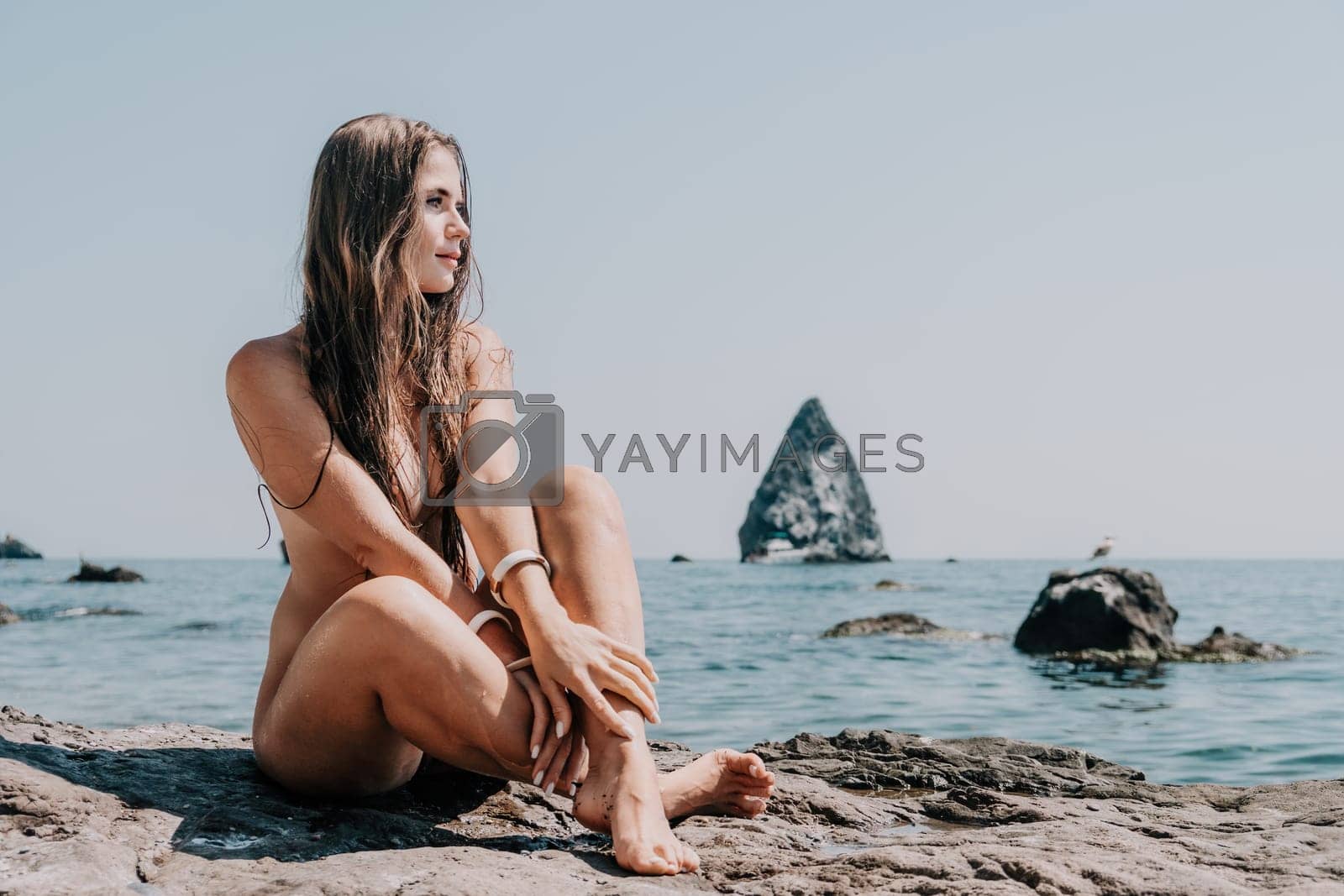 Royalty free image of Woman summer sea. Happy woman swimming with inflatable donut on the beach in summer sunny day, surrounded by volcanic mountains. Summer vacation concept. by panophotograph