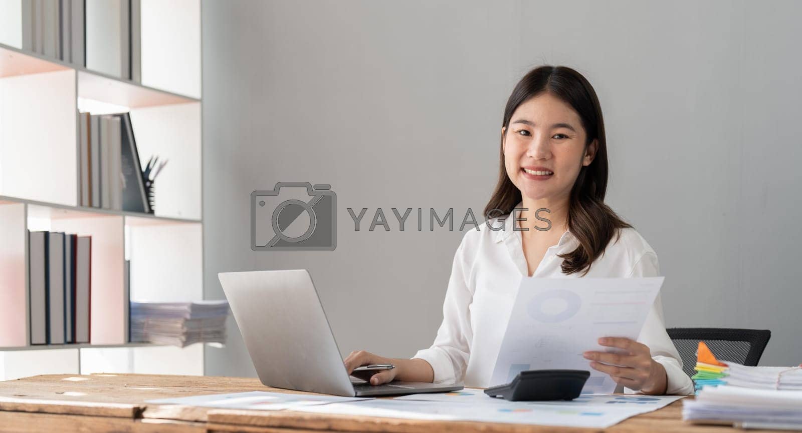 Royalty free image of business woman analyst sales management, taxes financial data documents or marketing report papers working in office using laptop. by nateemee