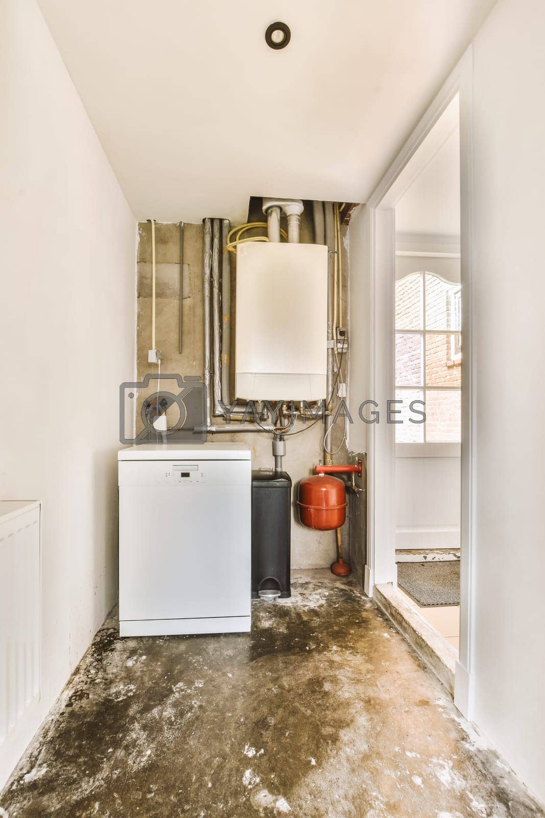 Royalty free image of a small kitchen with a white refrigerator and exposed pipes by casamedia