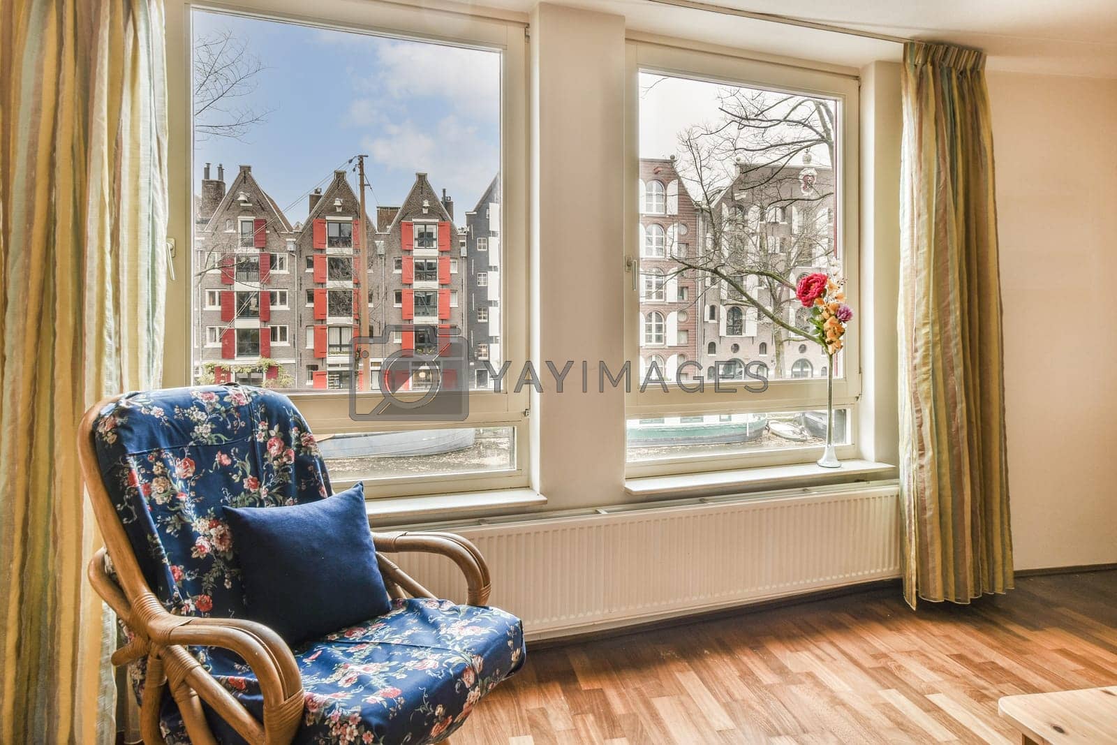 Royalty free image of a room with a chair and a window with houses by casamedia