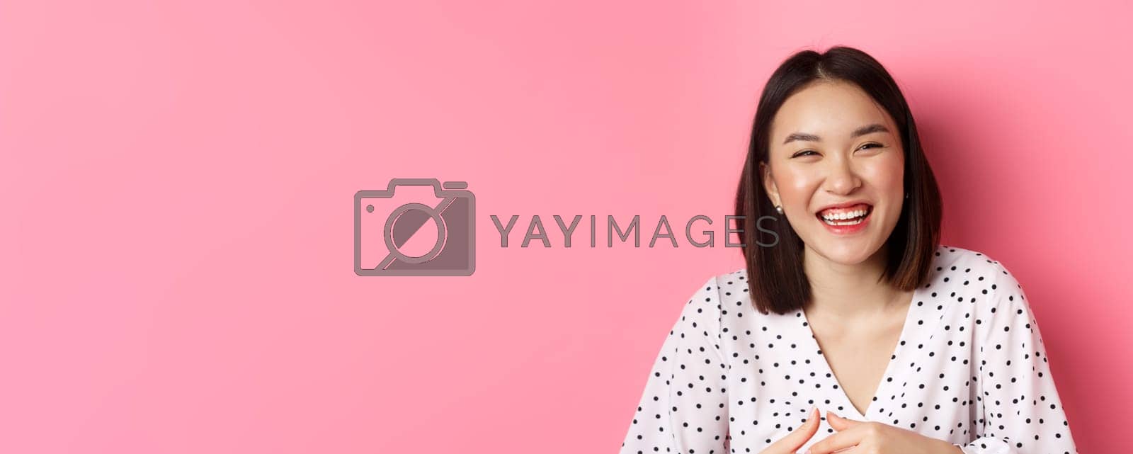 Royalty free image of Beauty and lifestyle concept. Close-up of happy asian woman laughing and having fun, standing over pink background by Benzoix