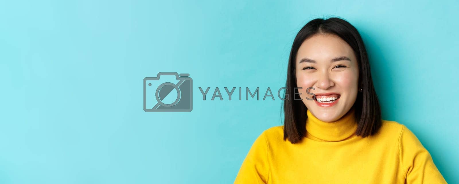 Royalty free image of Beauty and makeup concept. Close up of carefree teenage girl smiling and laughing sincere, having fun, standing over blue background by Benzoix