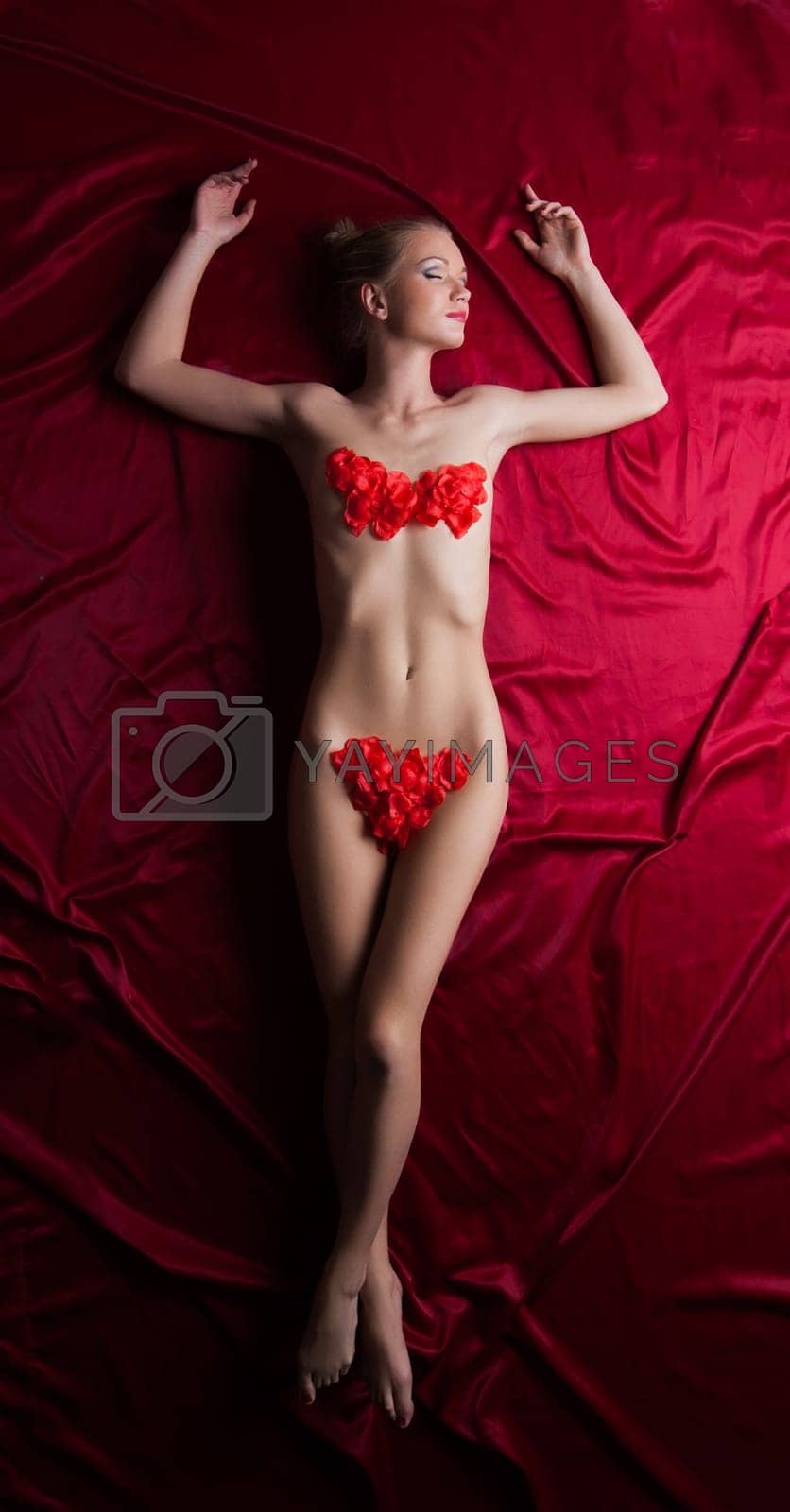 Royalty free image of Sexy woman with perfect body lay in rose petals by rivertime