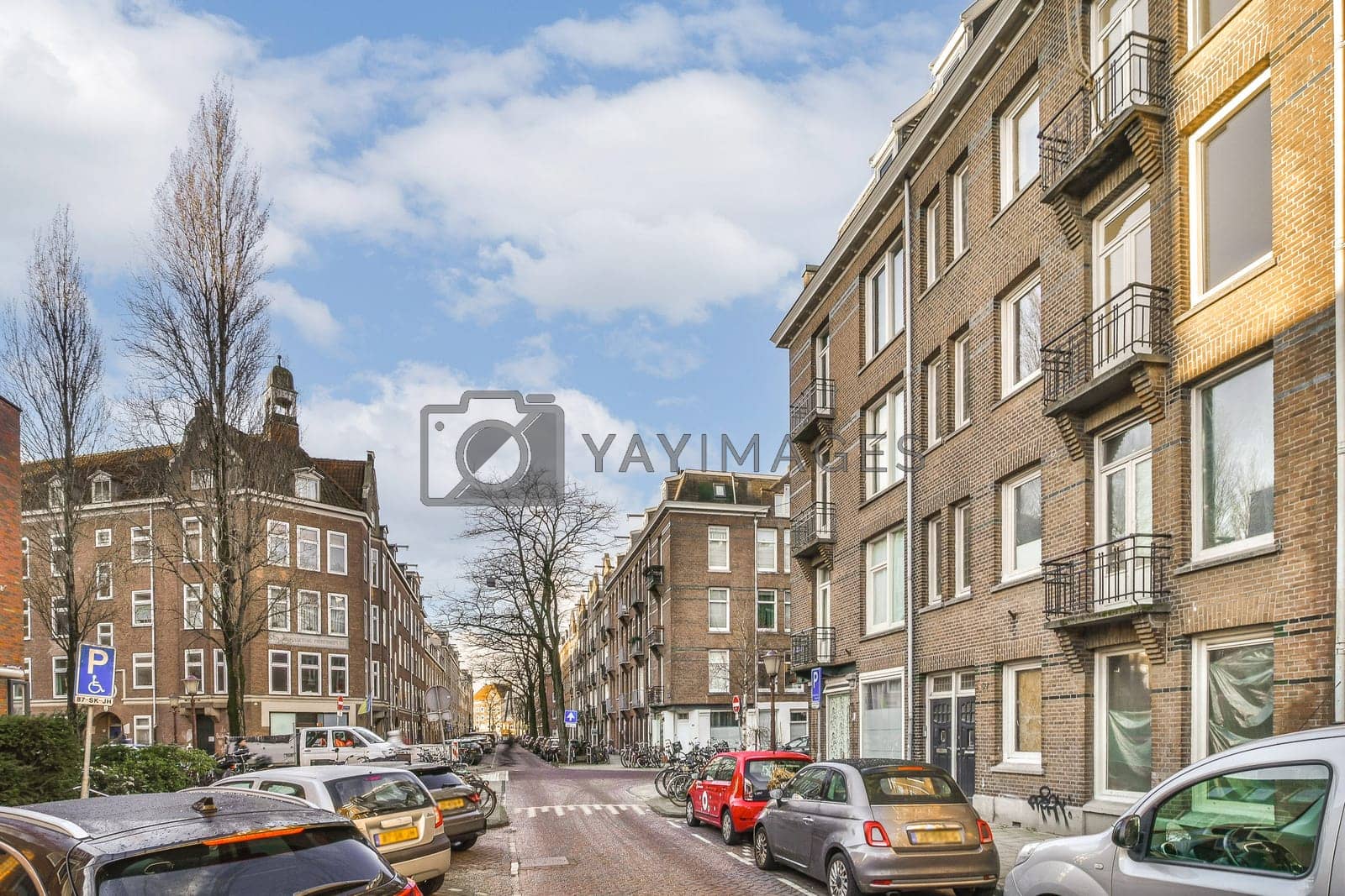 Royalty free image of a city street filled with cars and brick buildings by casamedia