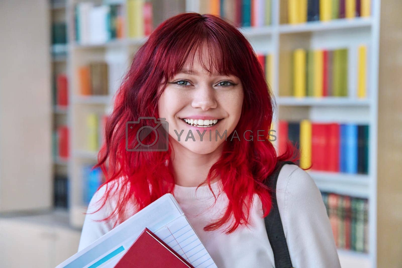 Royalty free image of Portrait of teenage female student looking at camera in library by VH-studio