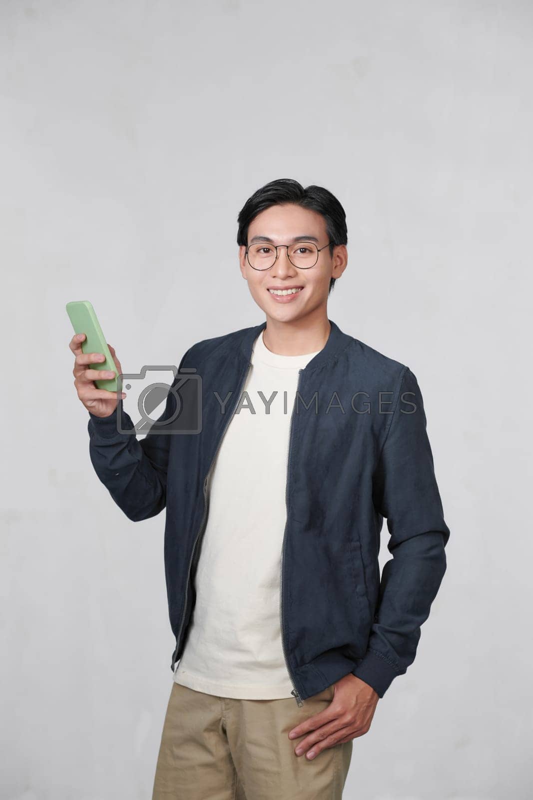 Royalty free image of Portrait of cheerful man using cellphone and smiling, reading good news message, enjoying mobile application by makidotvn