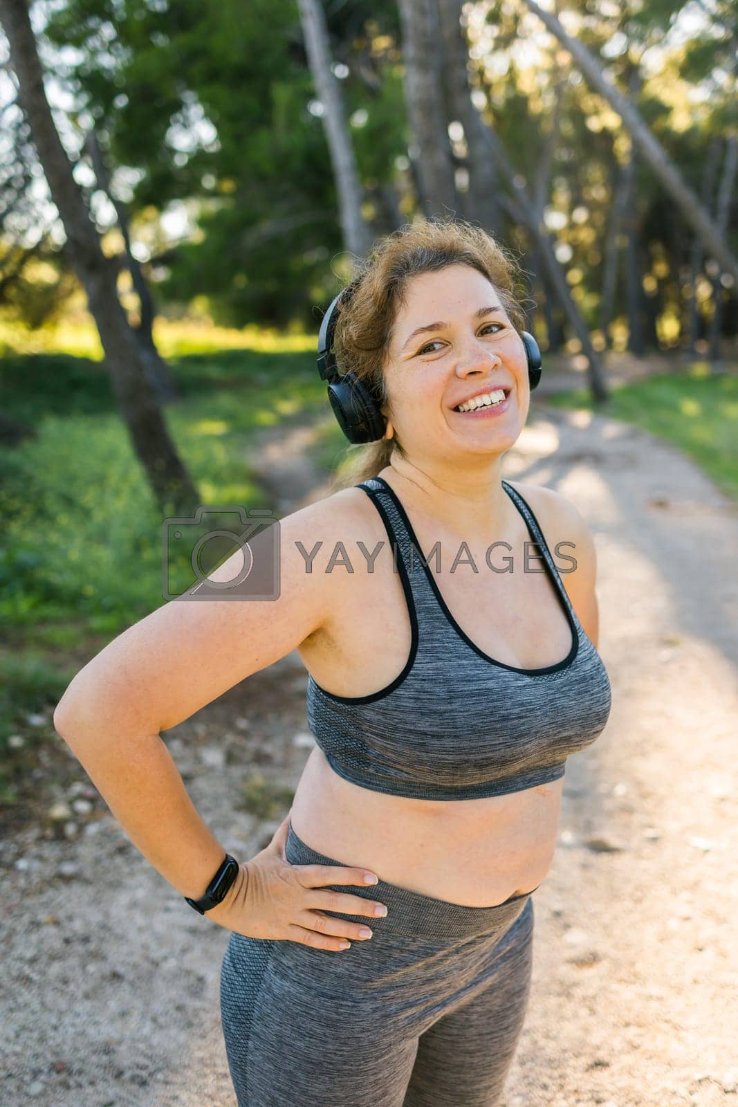 Royalty free image of Fat woman and sports. Girl doing exercise for weight loss in the fresh air and laughing in camera after training by Satura86