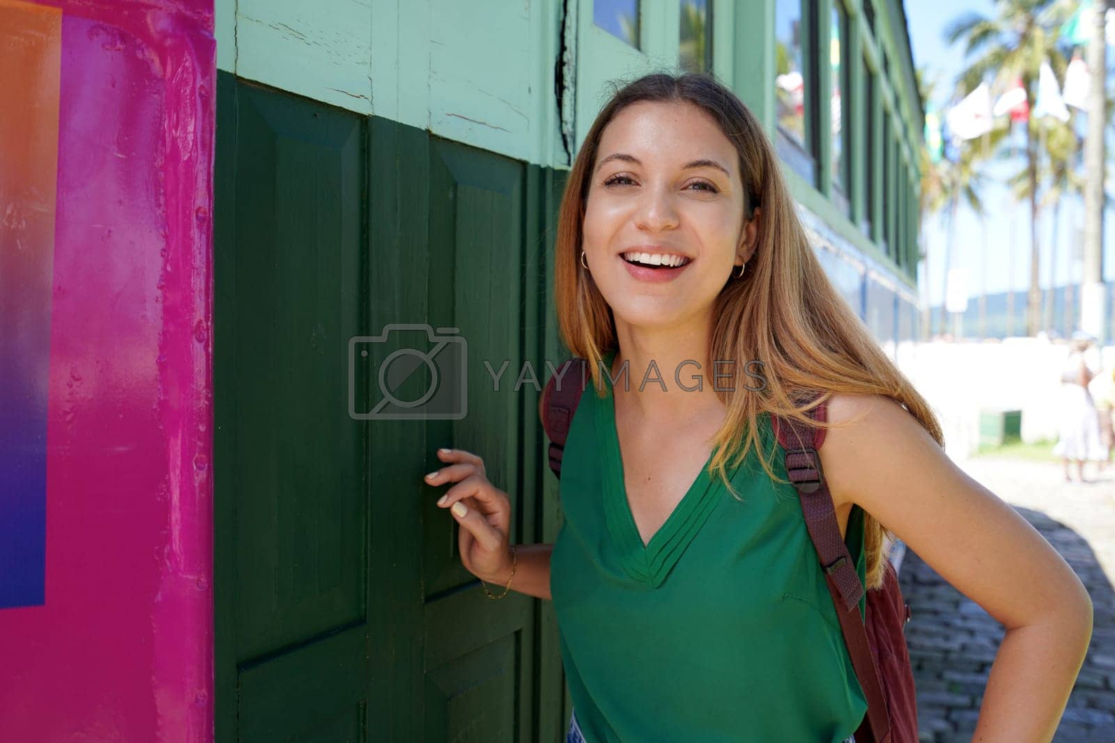 Royalty free image of Portrait of smiling traveler girl with backpack posing looking at camera  by sergio_monti