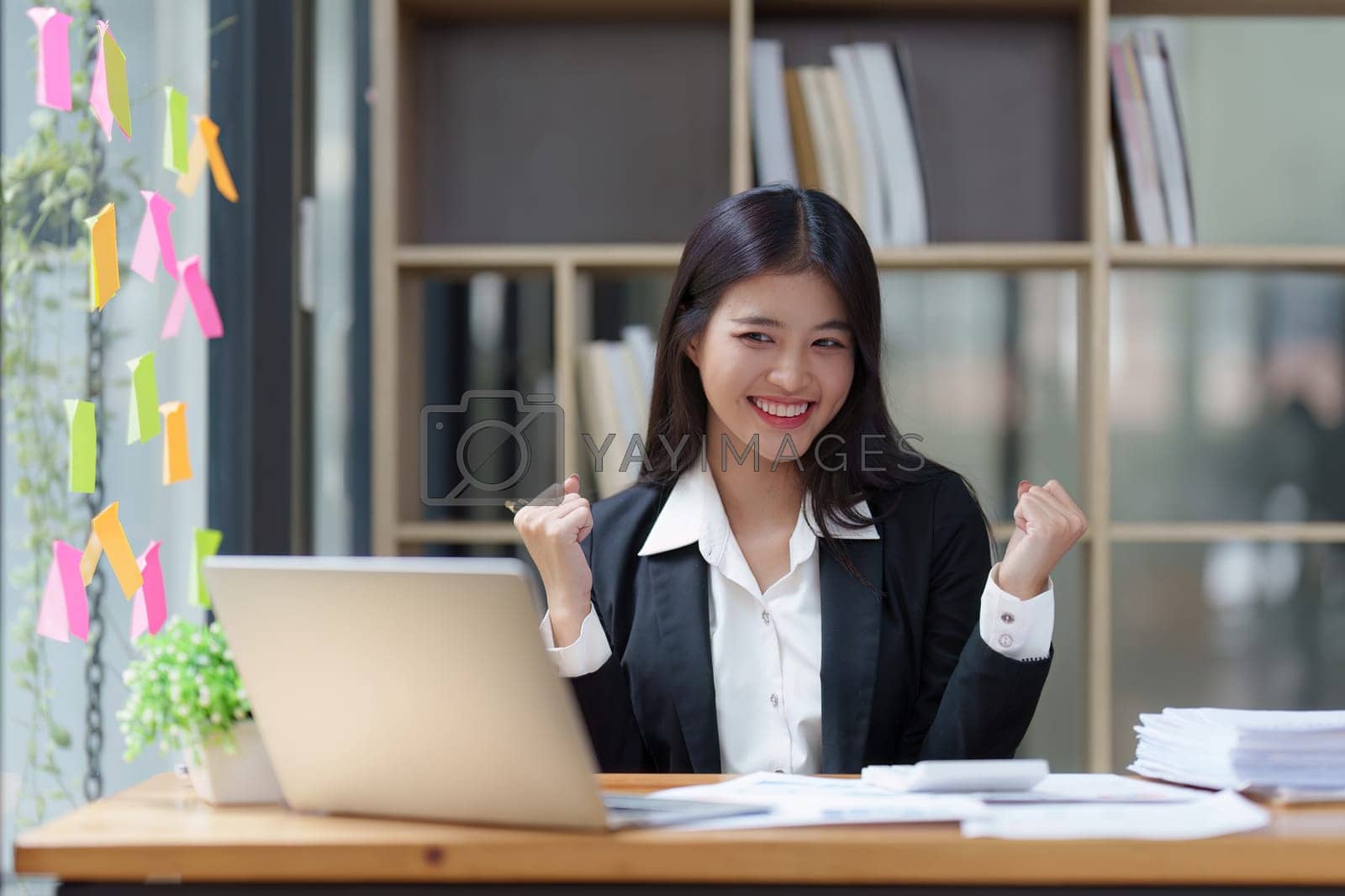 Royalty free image of Asian Businessperson using laptop and celebrating victory and success, have good news, job celebrating achievement. by itchaznong