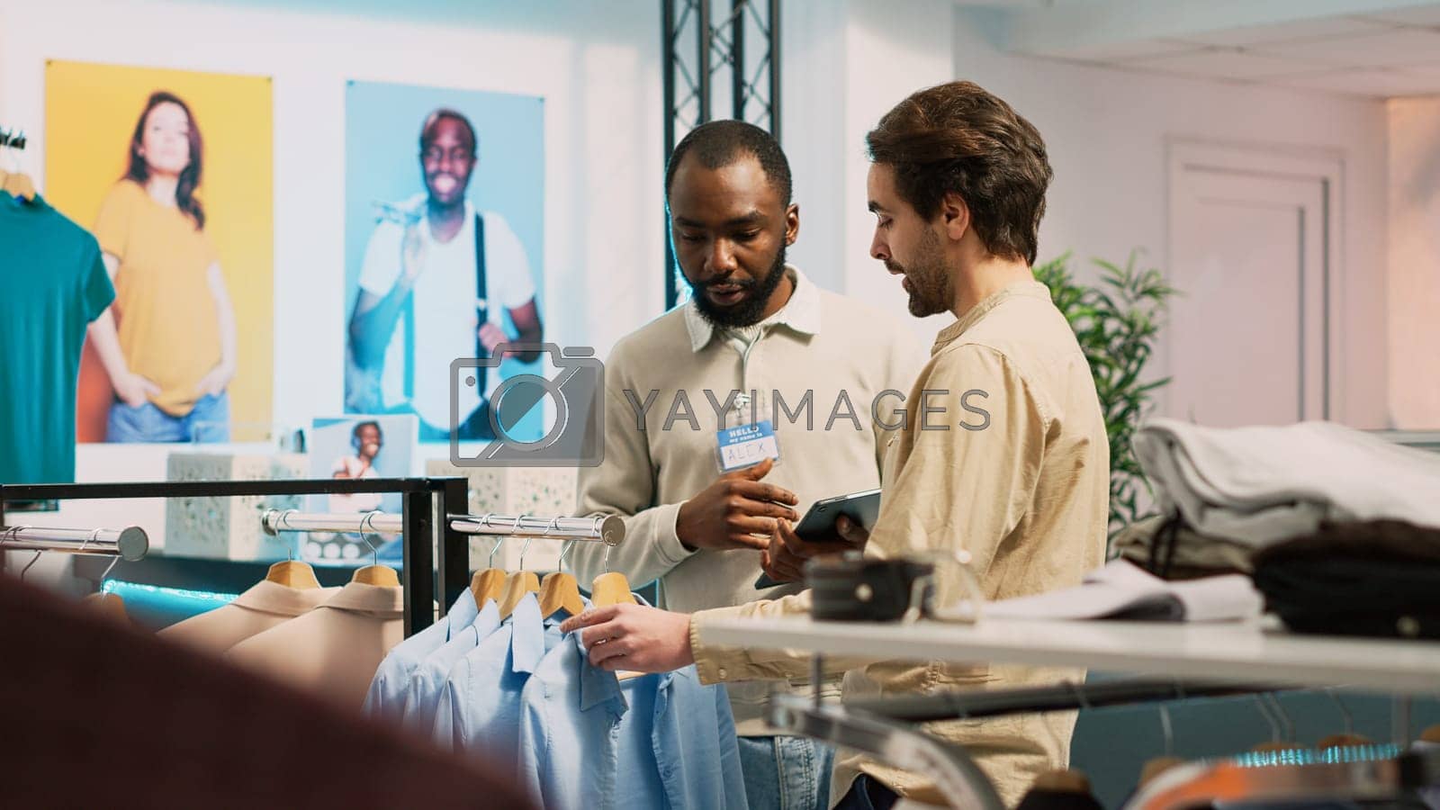 Royalty free image of Shop employee helping customer with modern trends by DCStudio