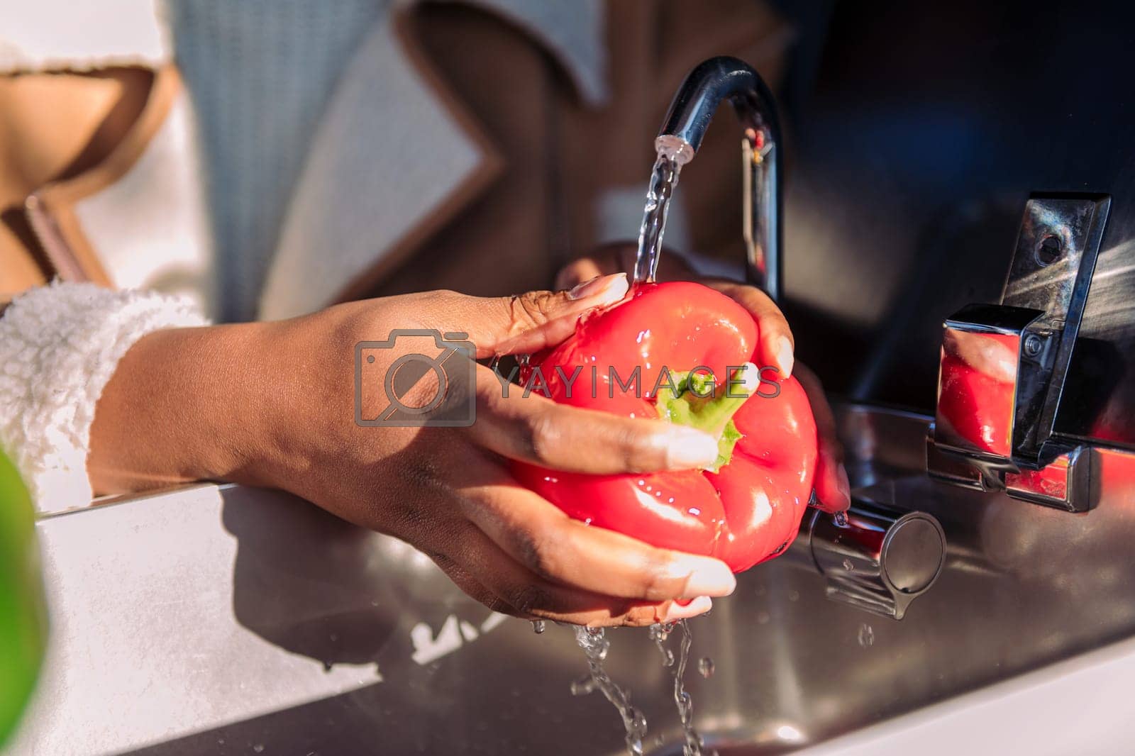 Royalty free image of washing red pepper in the sink of a camper van by raulmelldo