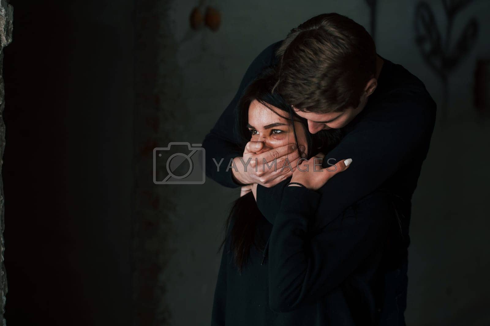 Royalty free image of Man's hand covering her mouth. Kidnapped woman is threatened by guy by Standret