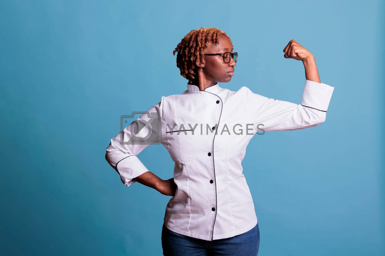 Royalty free image of Female cook flexing arm with pose of power by DCStudio