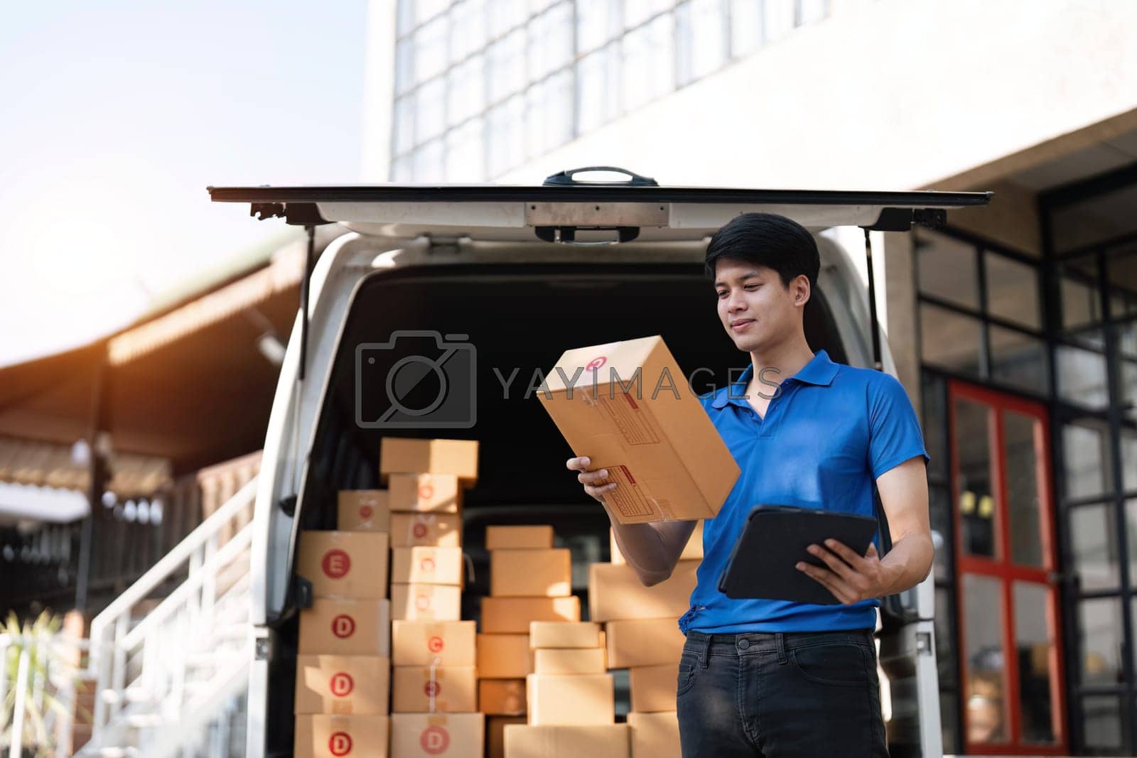 Royalty free image of Asian courier with parcel and delivery logistic concept. Delivery man checking address order from cardboard by nateemee
