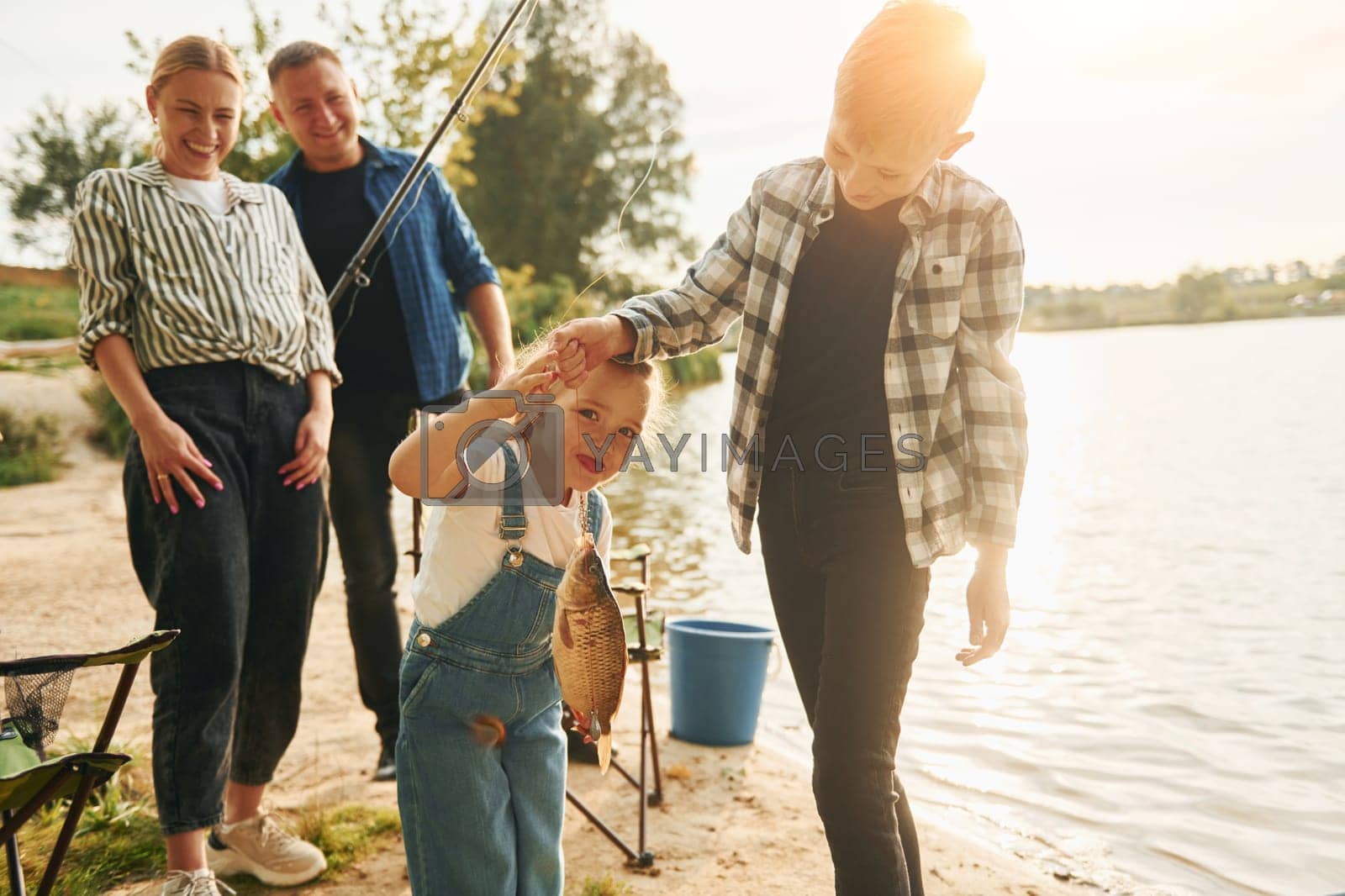 Royalty free image of Positive emotions. Father and mother with son and daughter on fishing together outdoors at summertime by Standret
