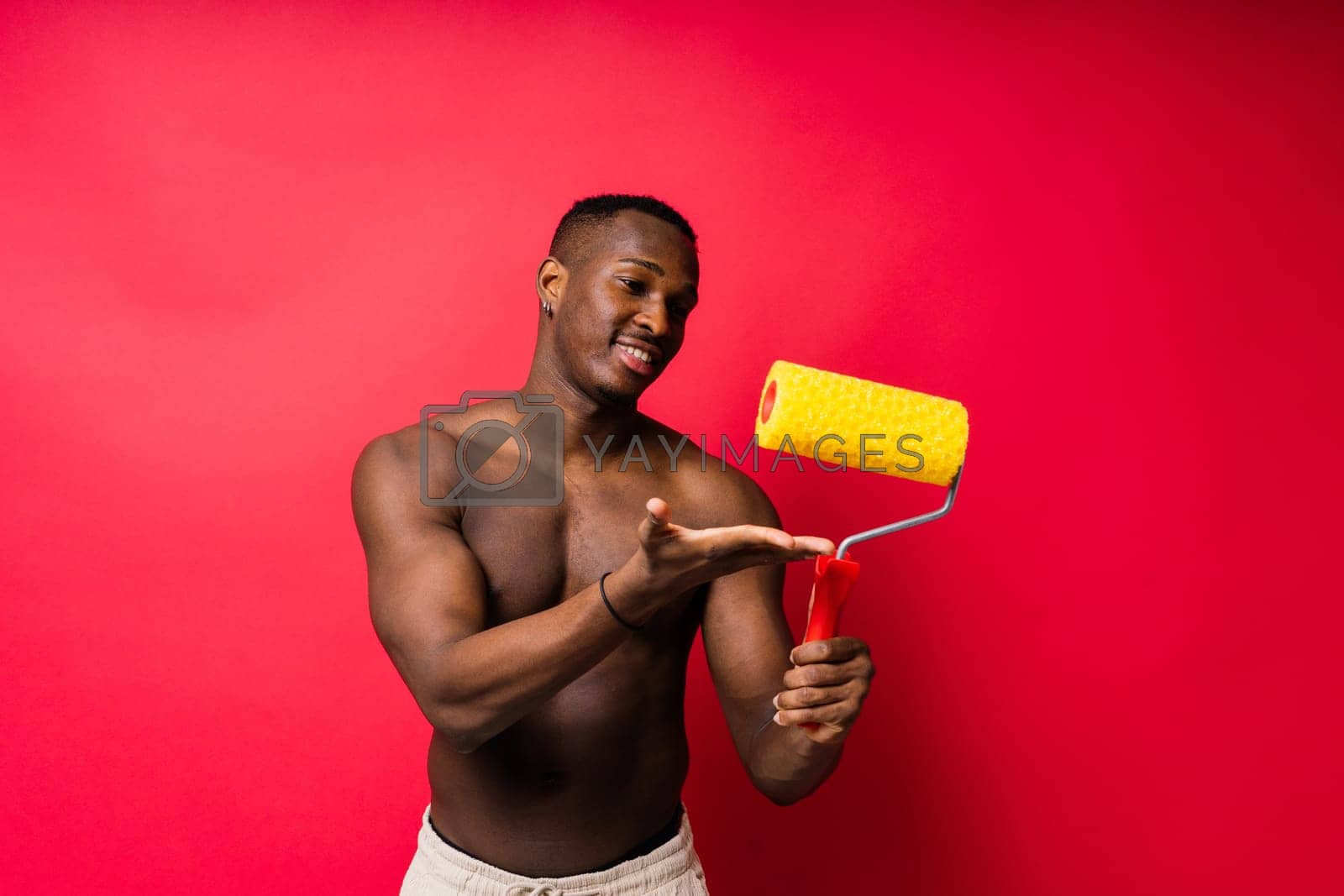 Royalty free image of African-American painter on red studio background topless by Zelenin