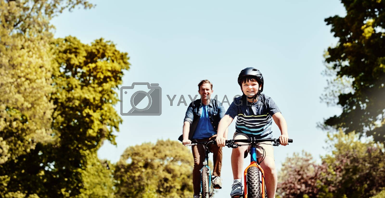 Royalty free image of Theyre a biking gang of their own. a young boy and his father riding together on their bicycles. by YuriArcurs