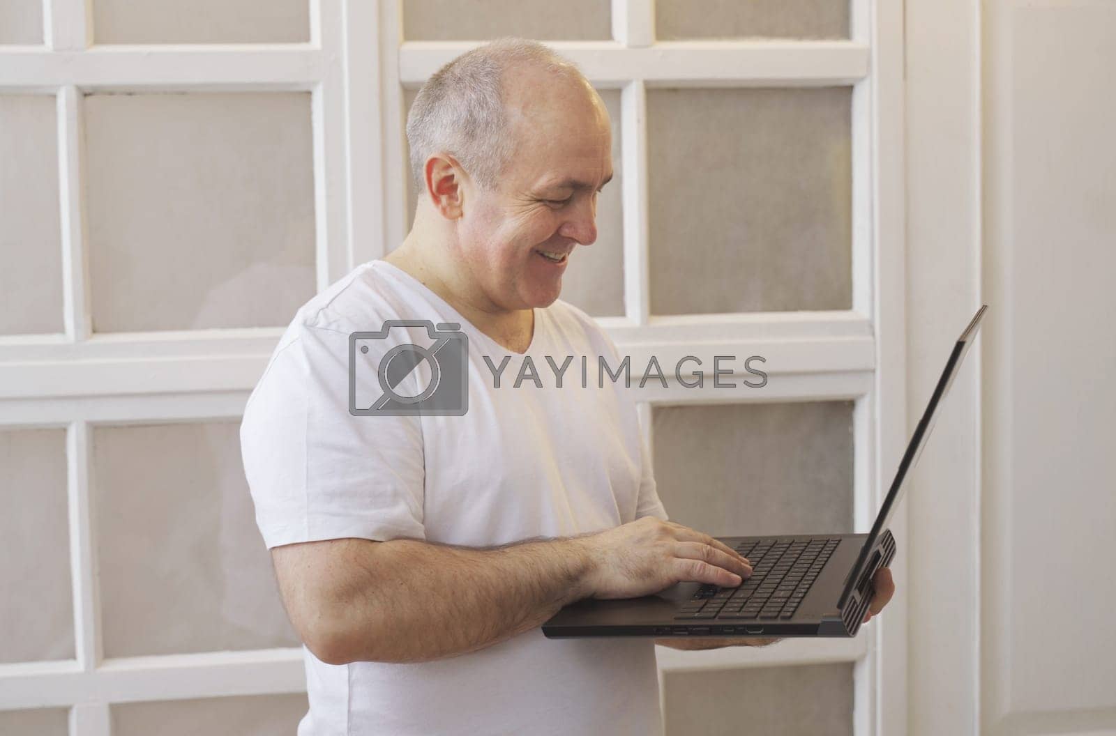 Royalty free image of A man with a laptop in his hands has a lively conversation on a video call by Sd28DimoN_1976