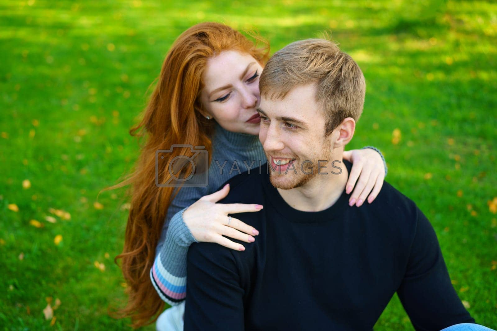 Royalty free image of Cheerful young couple in the park on the grass by EkaterinaPereslavtseva